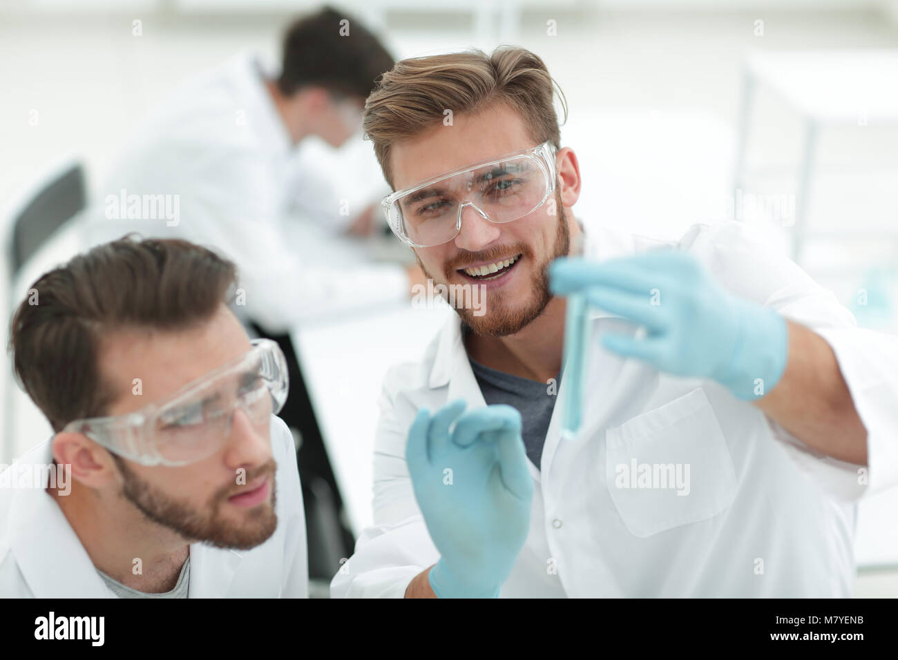 two biologist examining liquid in a test tube Stock Photo - Alamy