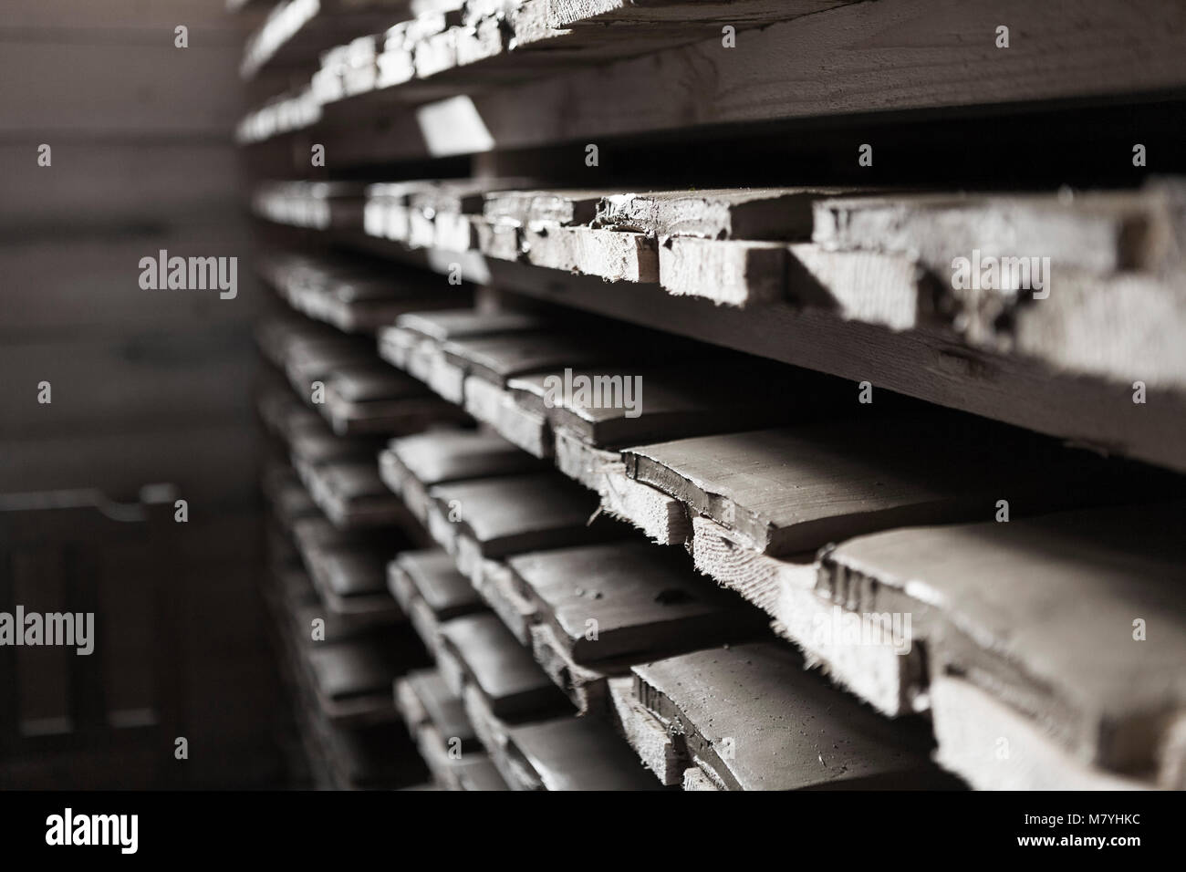 Clay roof tiles stacked on shelves ready to be fired in a kiln Stock
