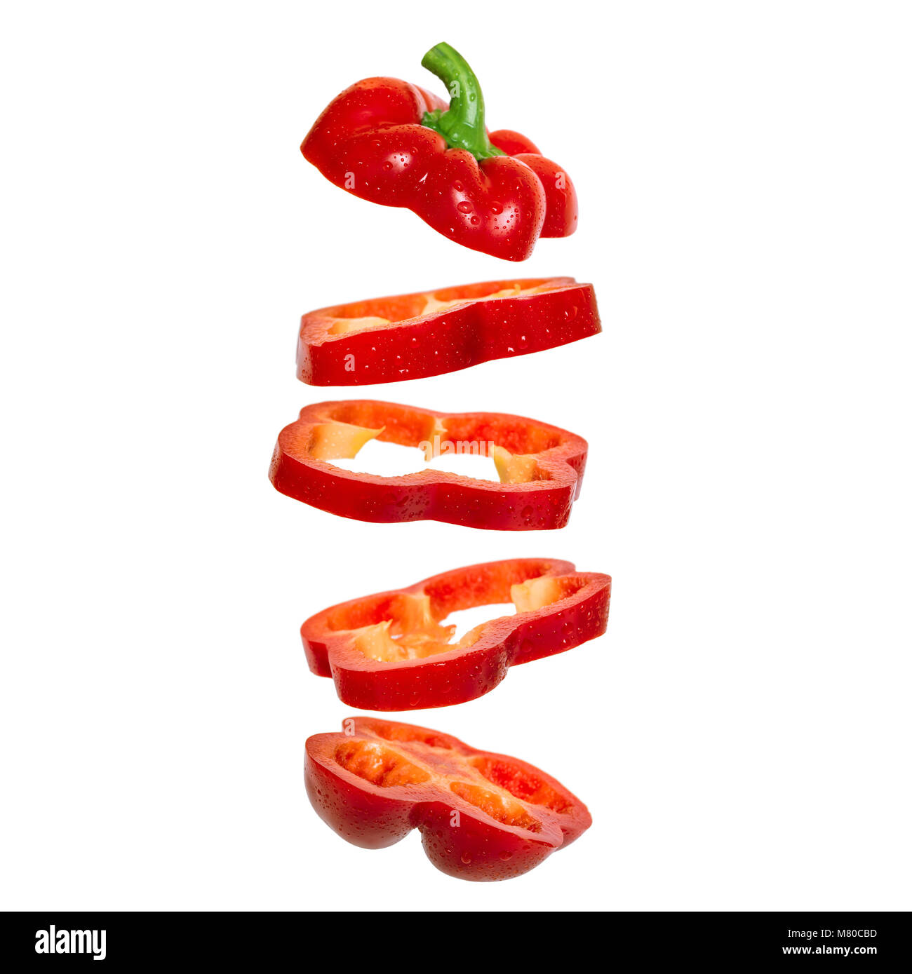 Creative concept with flying red paprika. Sliced floating pepper. Levity capsicum vegetable isolated on white background Stock Photo