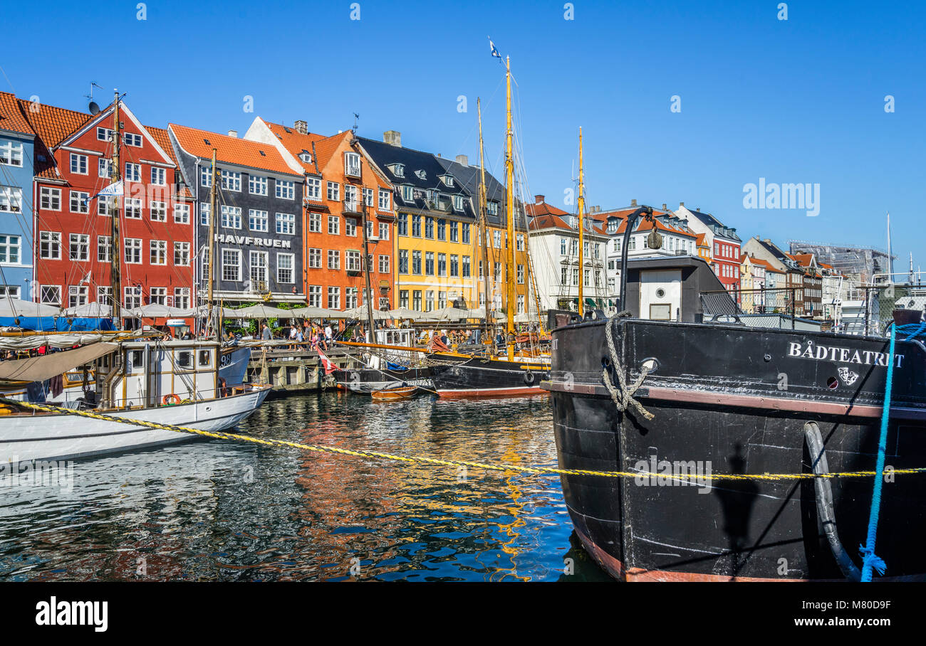 Denmark, Zealand, Copenhagen, view of the canal harbour waterfront of Nyhaven, with brightly coloured townhouses, restaurants, cafes and historic wood Stock Photo