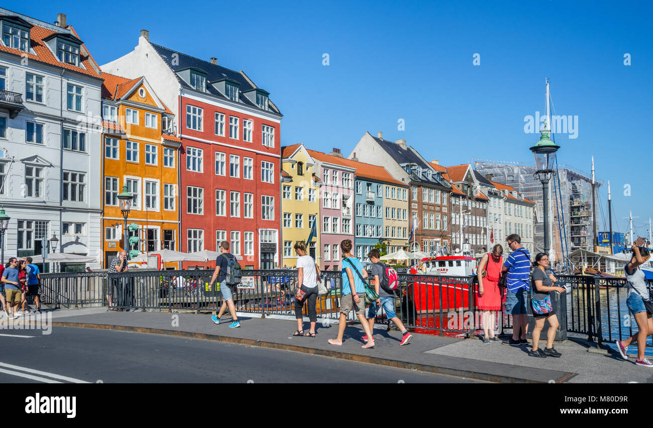 Denmark, Zealand, Copenhagen, view of the canal harbour waterfront of Nyhaven, with brightly coloured townhouses, restaurants, cafes and historic wood Stock Photo