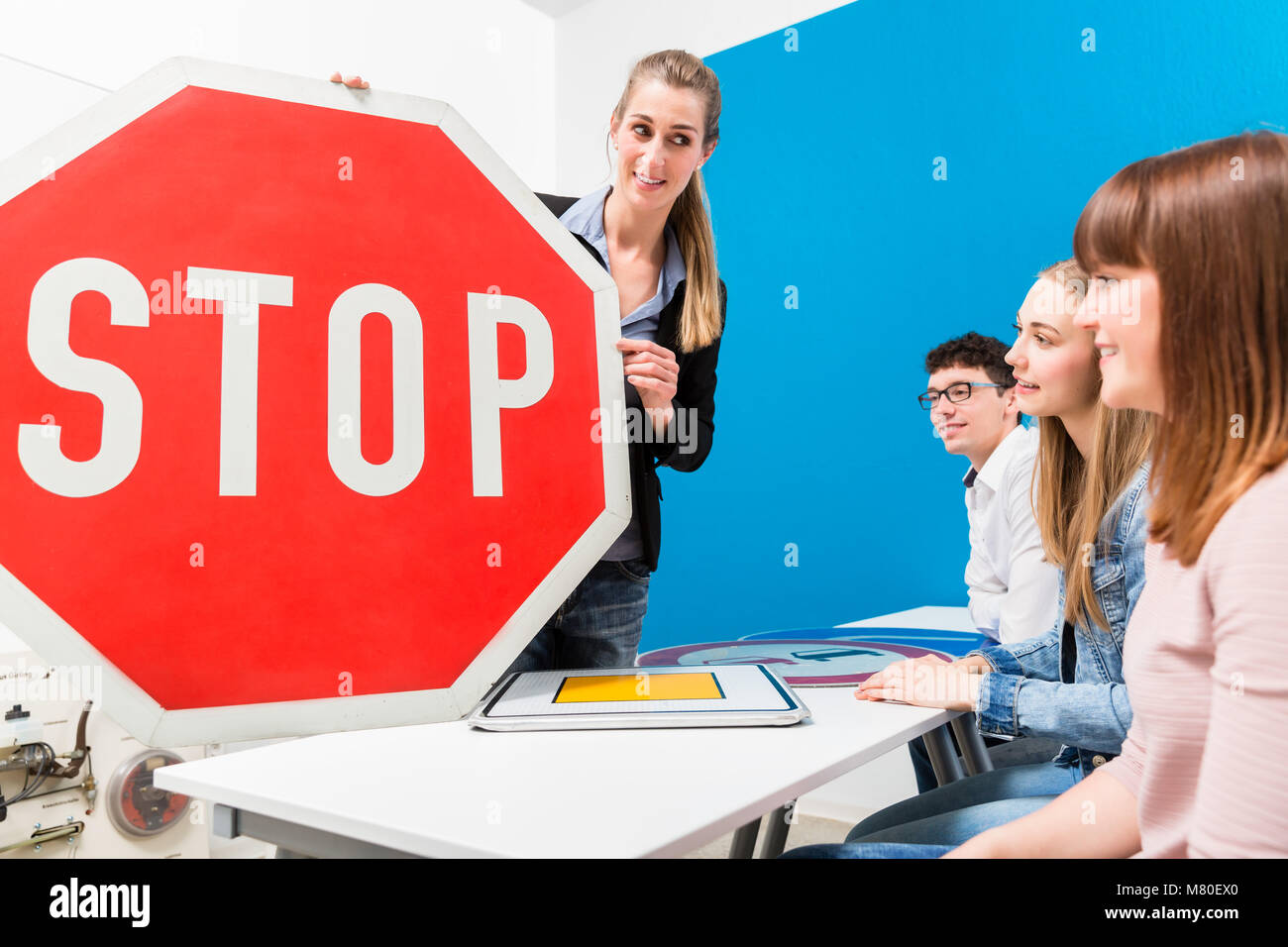 Driving teacher explaining meaning of street signs to class Stock Photo
