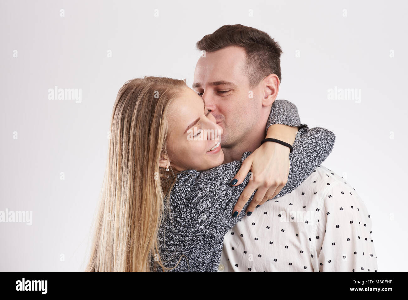 Young man kissing blonde woman isolated on white background Stock Photo
