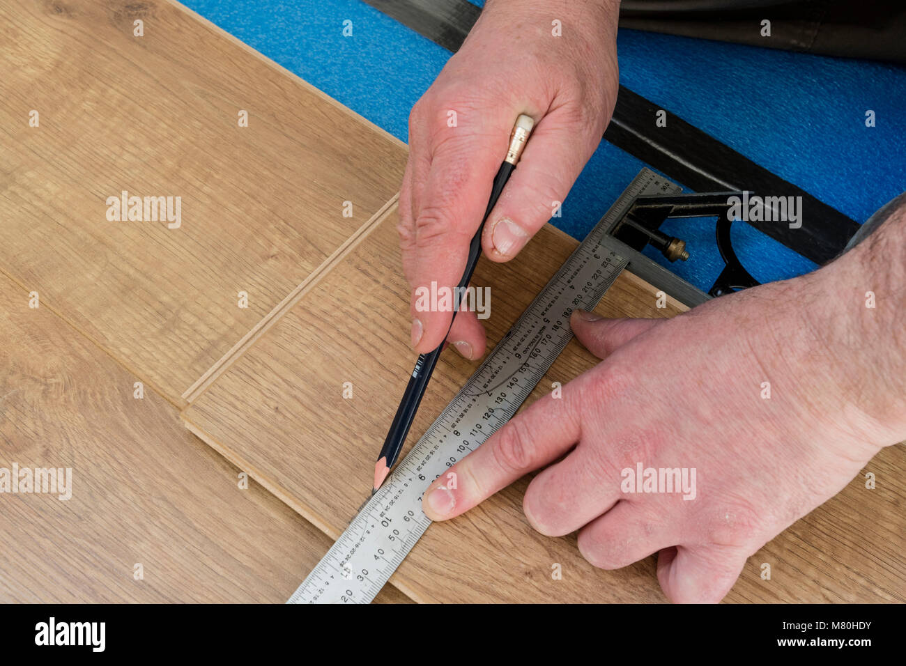 A Person Marking Out a Laminated Floor Board Ready for Cutting Using a Combination Set Square, UK. Stock Photo