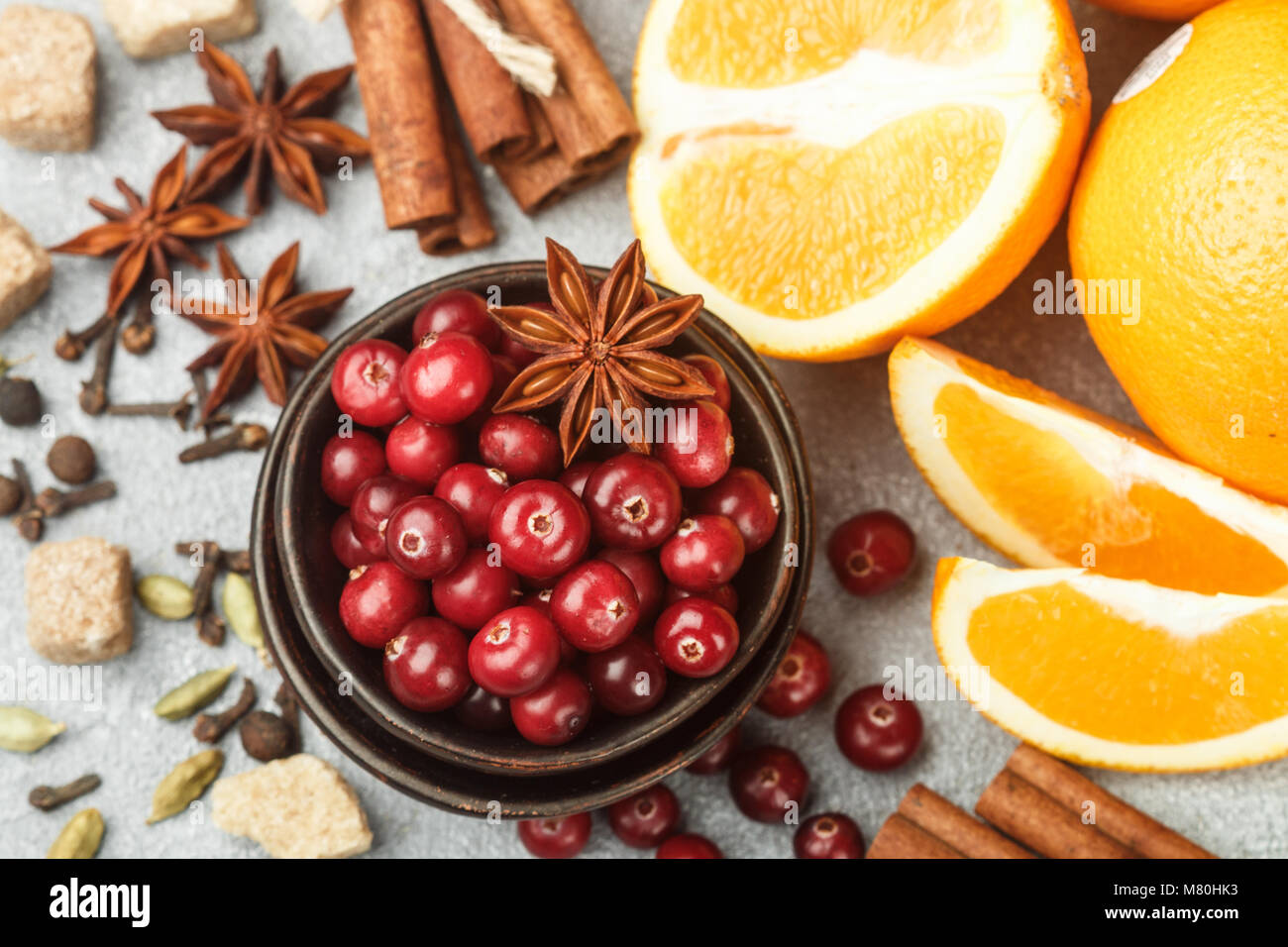 Ingredients for cooking traditional spicy winter drinks - cranberry, citrus, cinnamon, cardamom, star anise, cloves, pepper. Non-alcoholic mulled wine Stock Photo
