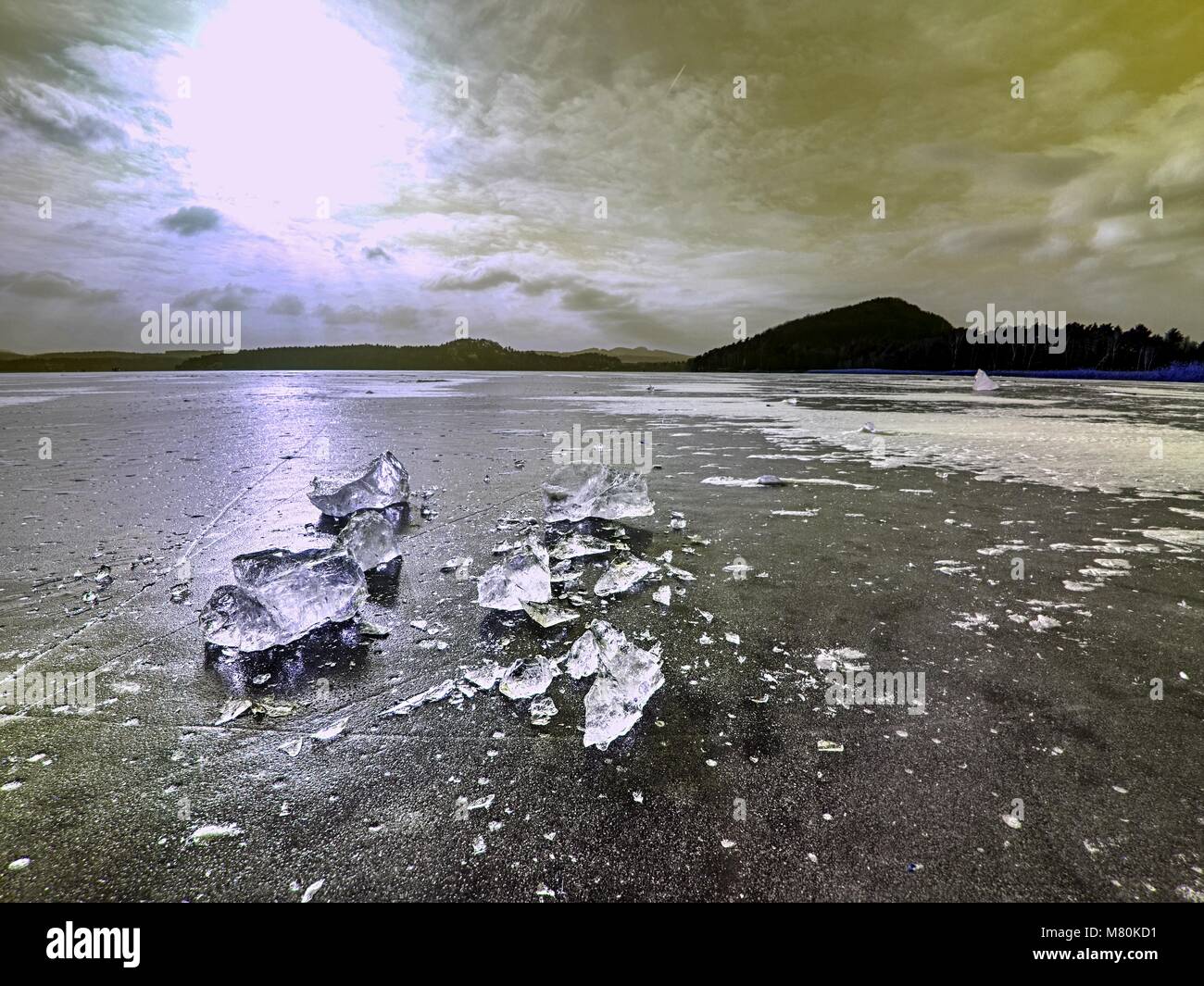 Shining shards of broken ice. Abstract still life of ice floes on lavel of frozen lake. Stock Photo