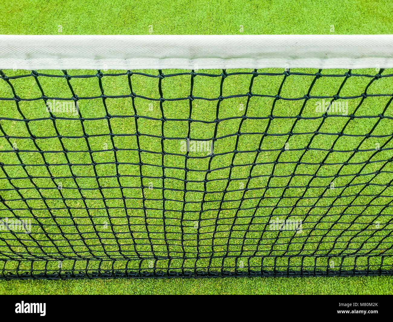 High angle view of net and green artificial turf abstract sport tennis playing field background Stock Photo