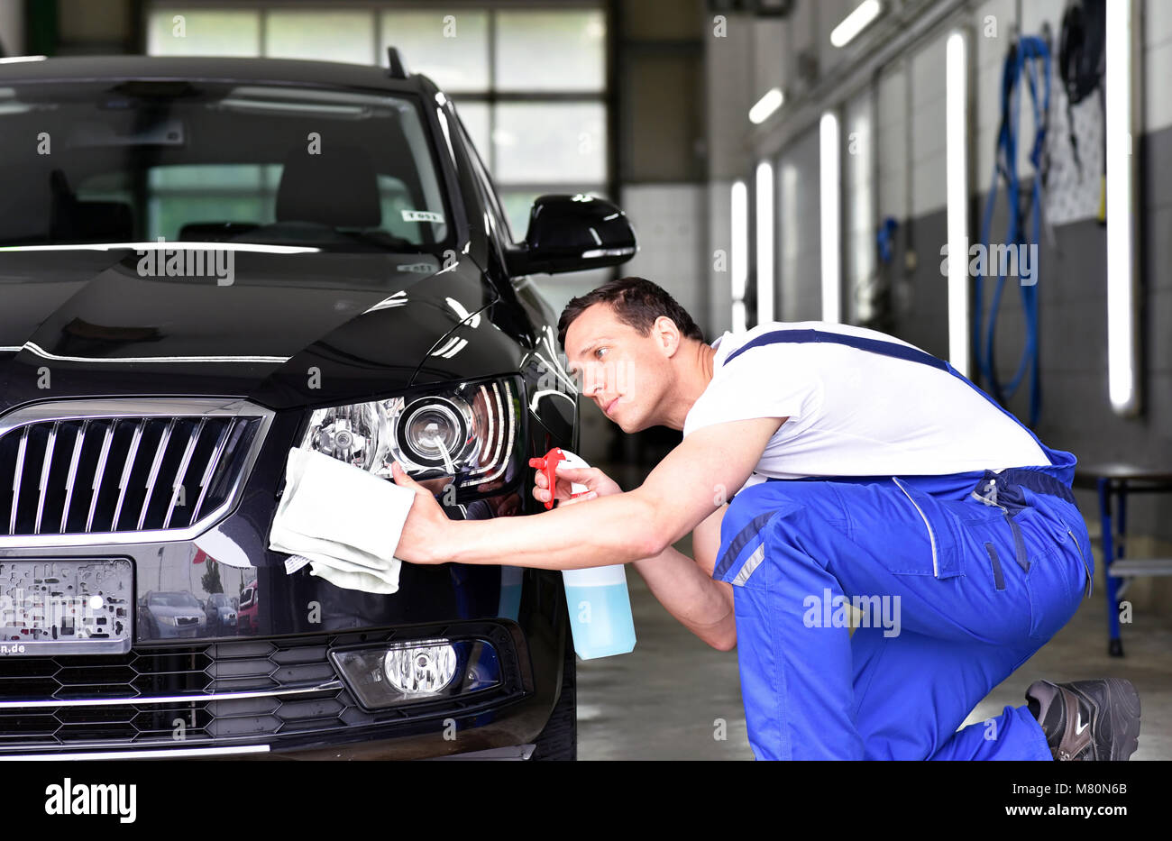 professional car wash - worker in a car dealership polishes the car paint Stock Photo