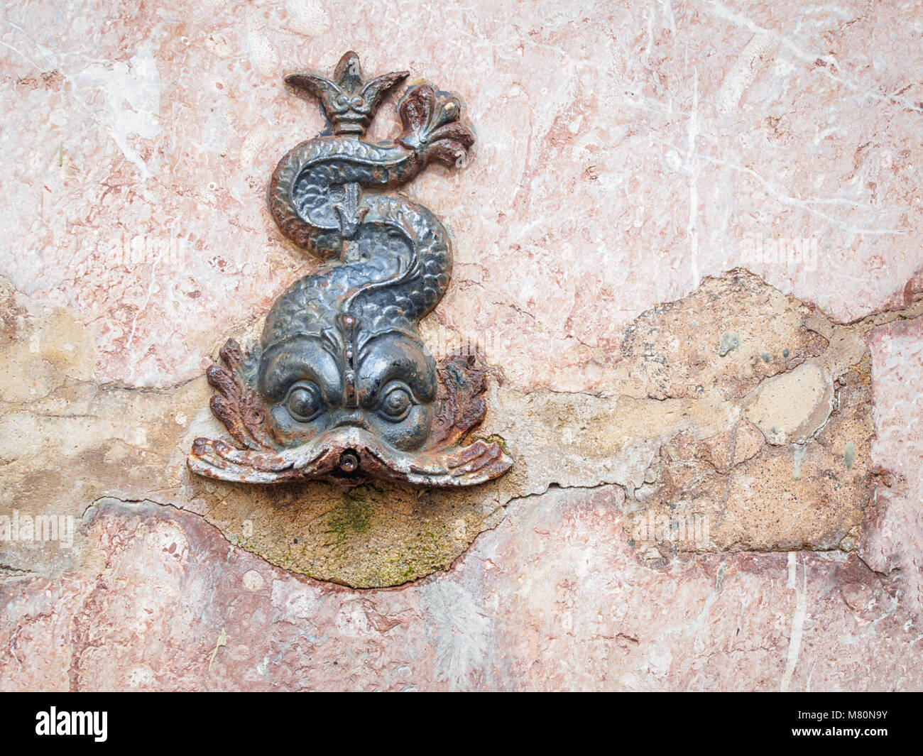 Metallic antique fish fontain sculpture on the wall Stock Photo