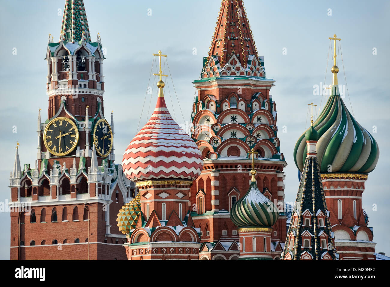 MOSCOW, RUSSIA - Kremlin Clock Tower & Onion Domes of St. Basil’s Cathedral in Winter Stock Photo