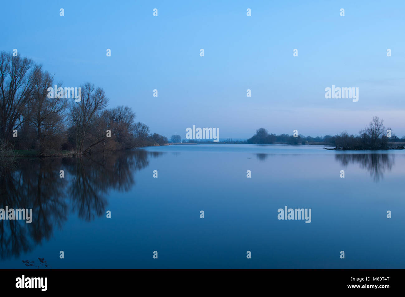 View at old Suederelbe and nature reserve Finkenwerder Suederelbe at calm evening. Long exposure at blue hour, Hamburg, Germany. Stock Photo