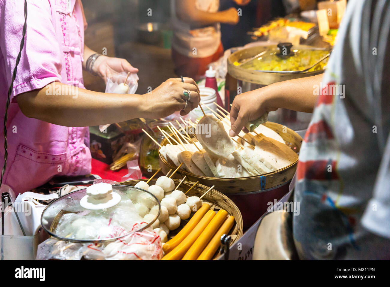 CHIANG MAI, THAILAND - AUGUST 21: Man buys street food at the Sunday Market (Walking Street) on August 21, 2016 in Chiang Mai, Thailand. Stock Photo