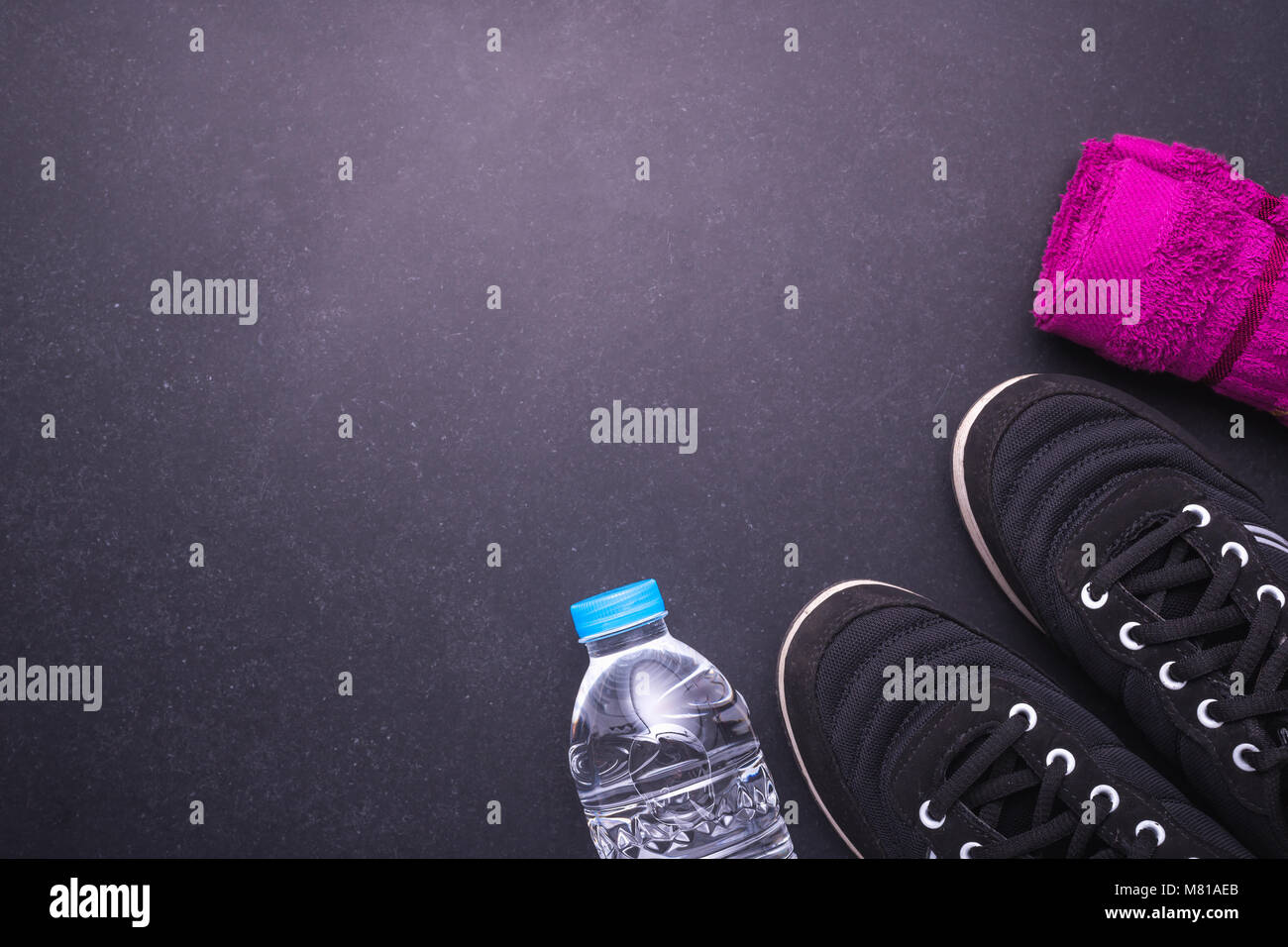 Black Running / Sneaker shoe, water bottle and towel on black stone floor. Exercise concept. Top view Stock Photo