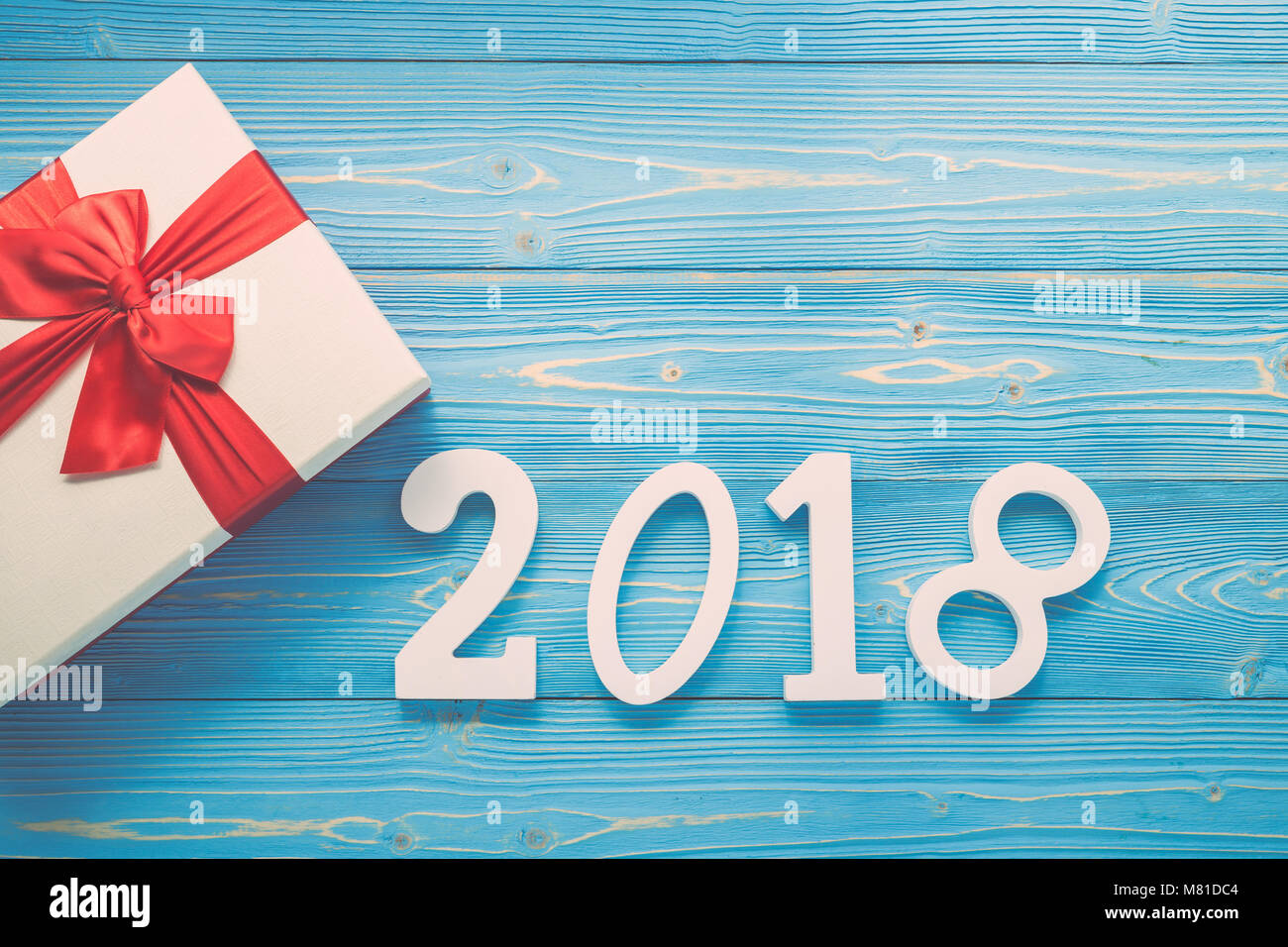 White new year or Christmas gift box with red ribbon for holiday concept on blue wooden board. Top view with empty space for text and design Stock Photo