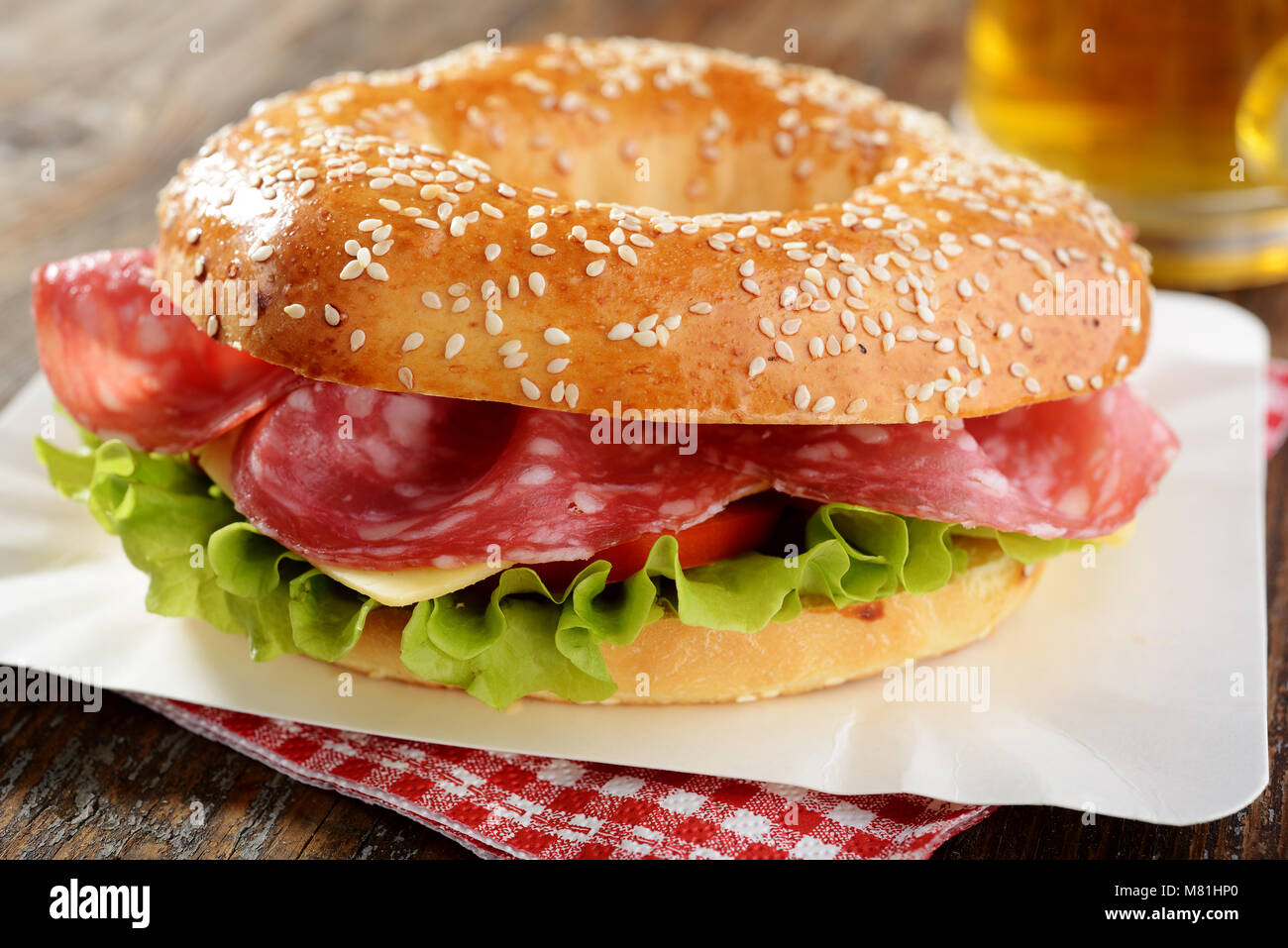 Bagel sandwich with sausage, cheese, and lettuce Stock Photo