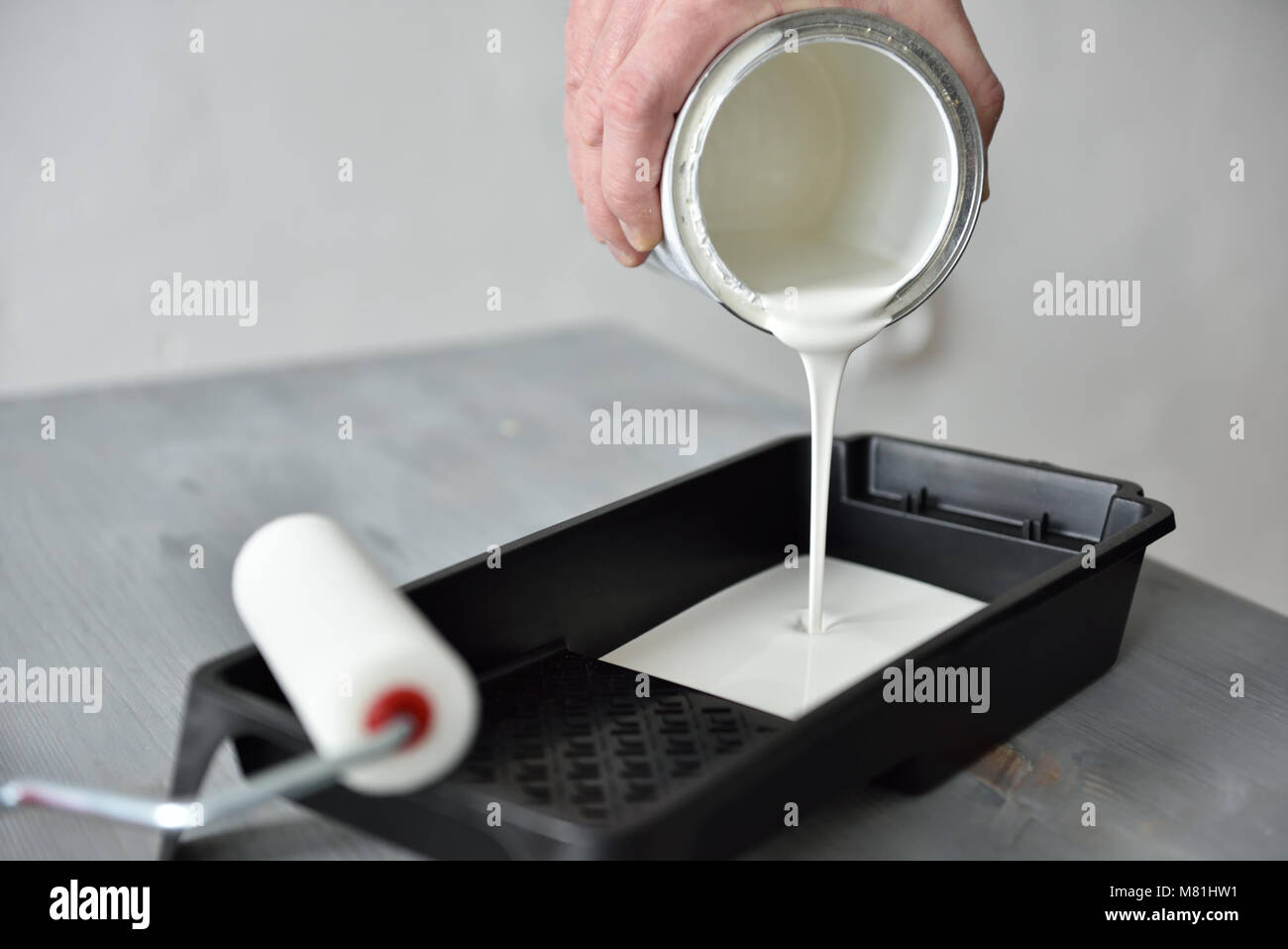 Man pouring paint into the painting tray Stock Photo Alamy