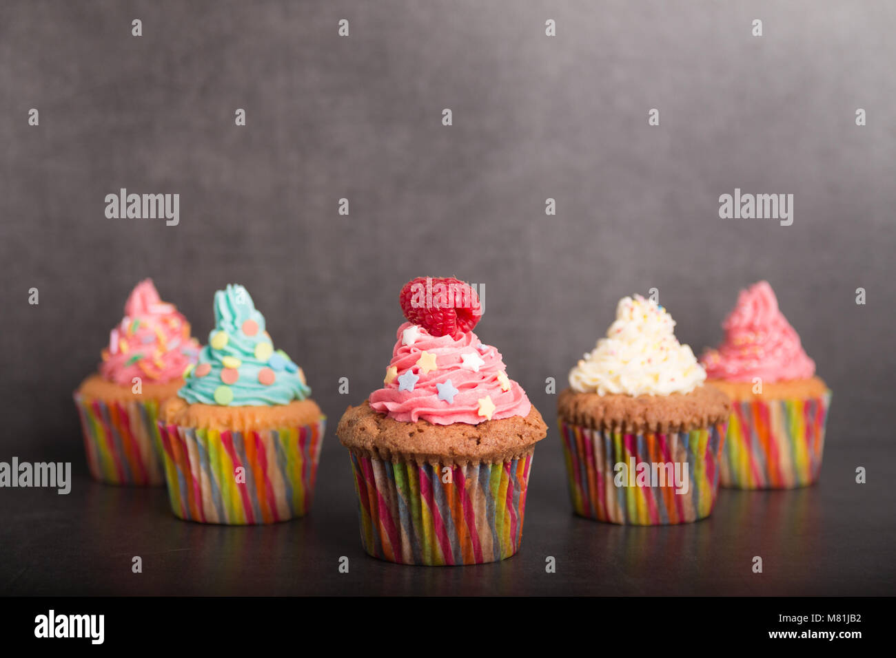 home baked cupcakes with colorful frosting and fruit Stock Photo Alamy