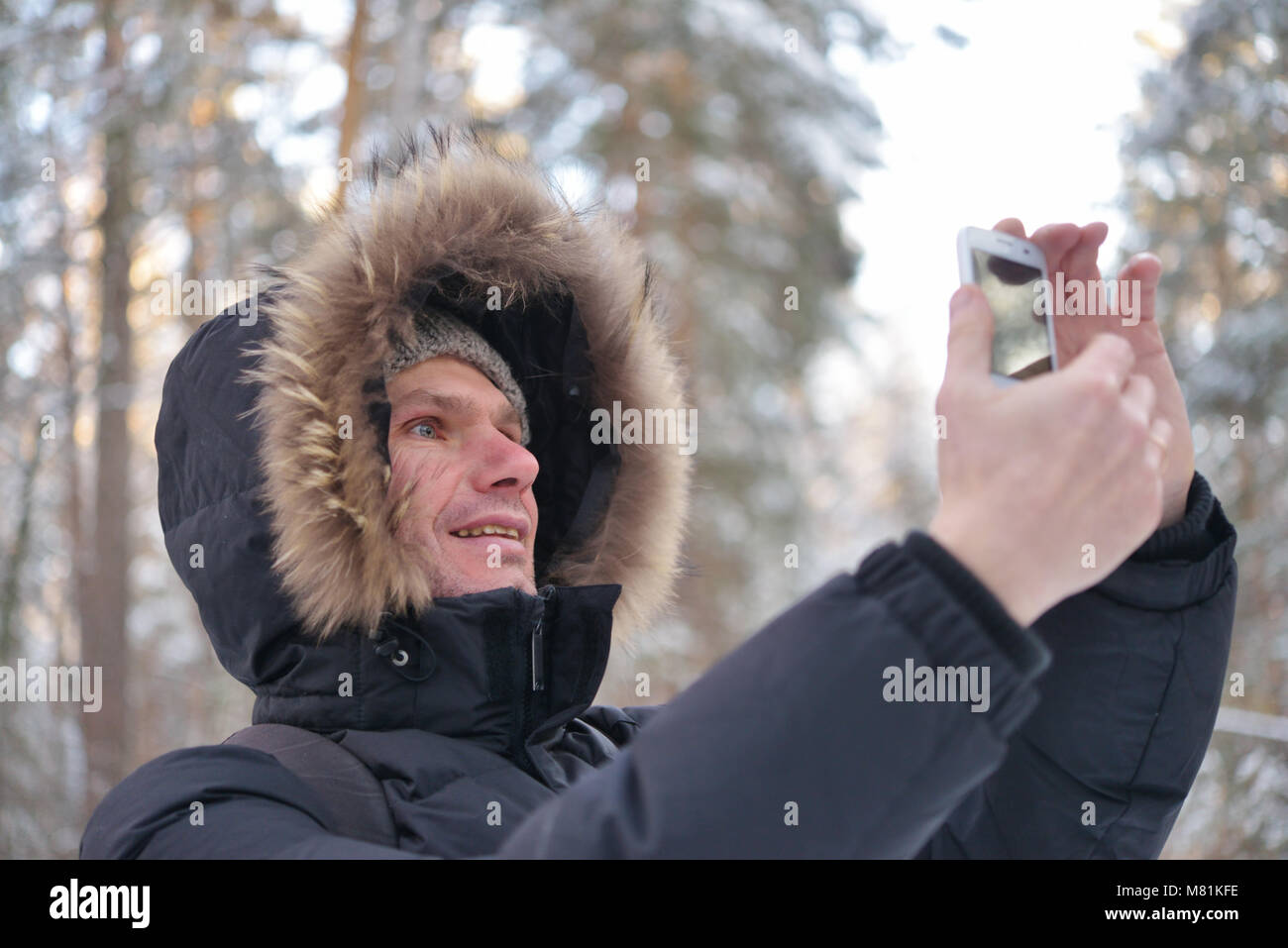 Man in winter clothes making selfie using smartphone Stock Photo - Alamy