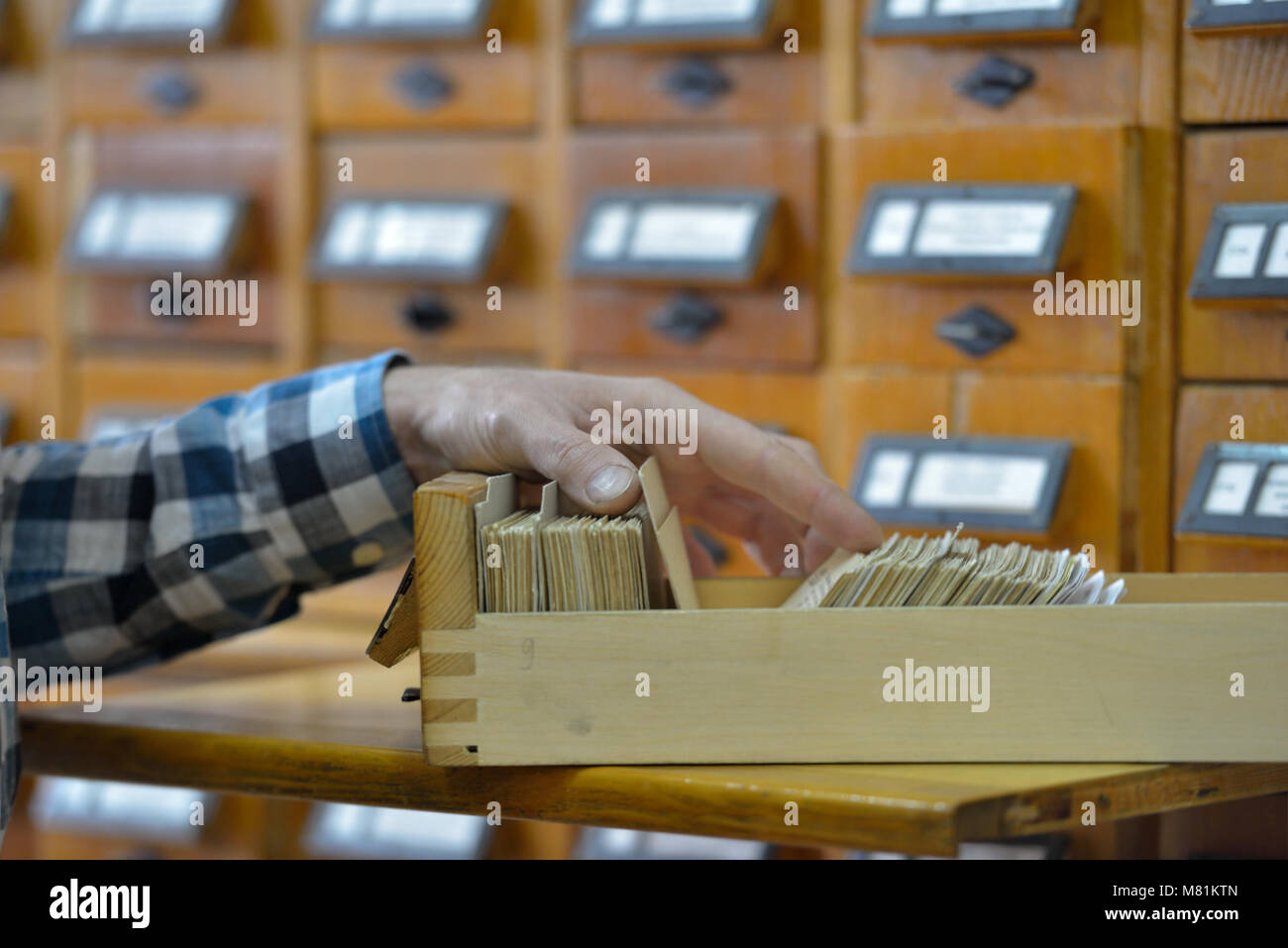Man searching a book in a library catalog Stock Photo Alamy