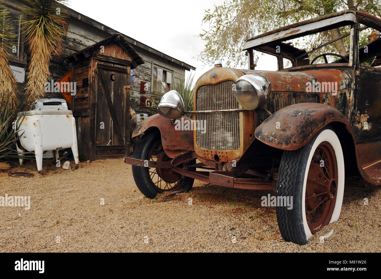 An outhouse and a rusty old Ford automobile are part of the display at the Hackberry General Store in Arizona, a Route 66 landmark. Stock Photo
