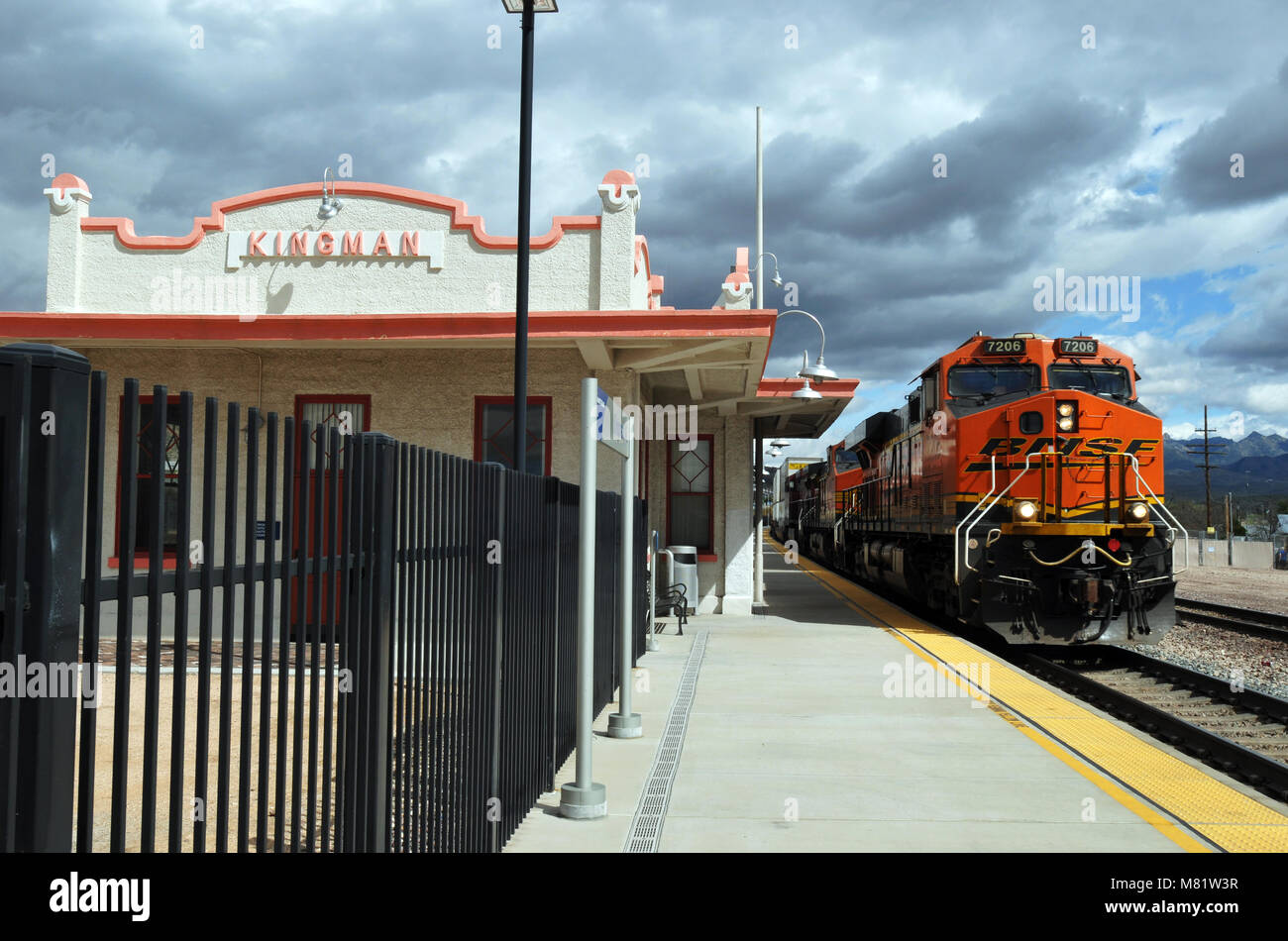 A freight train rumbles past the restored railroad depot in Kingman
