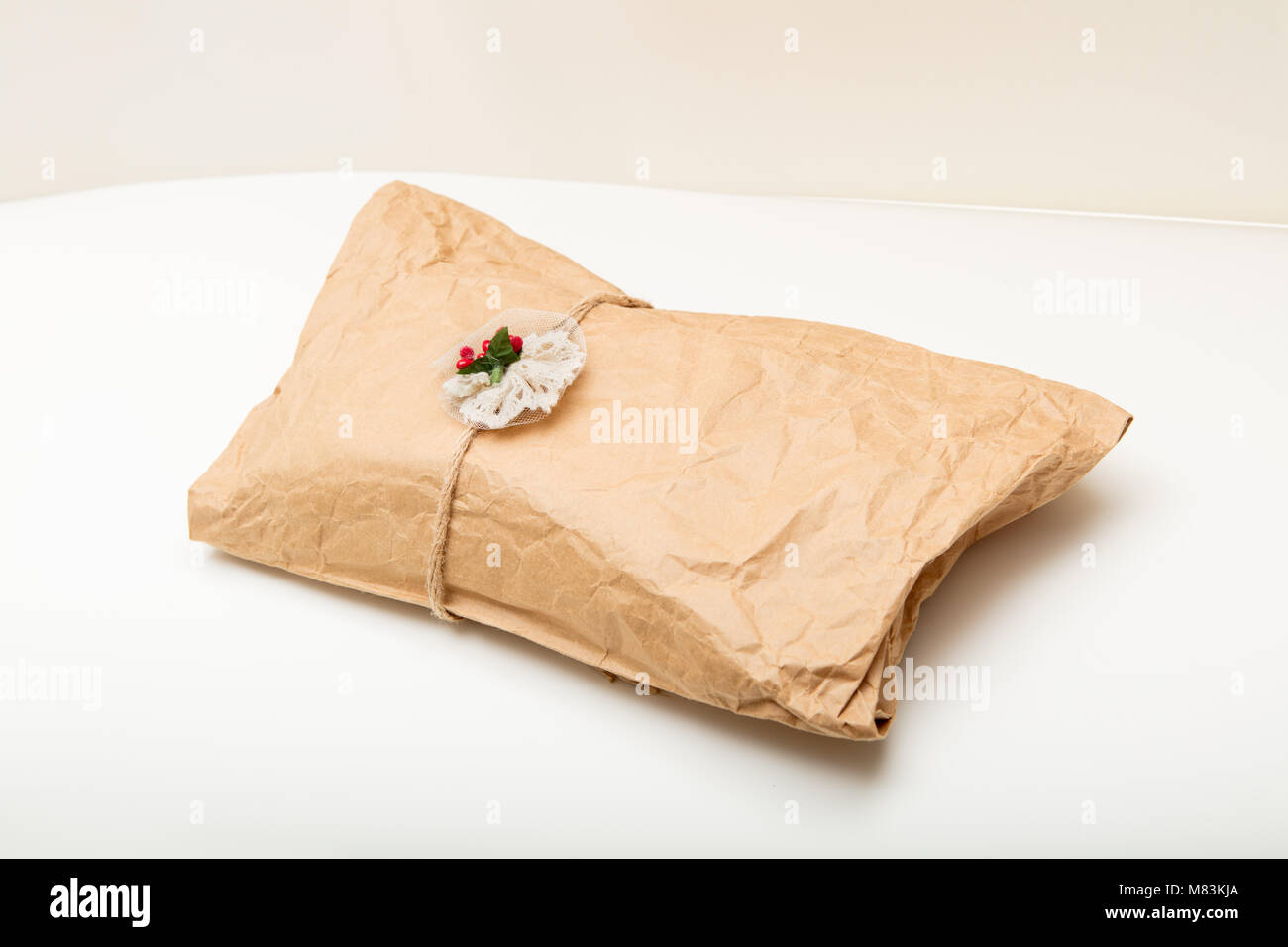 Gift In Crumpled Wrinkled Brown Paper Tied With String And