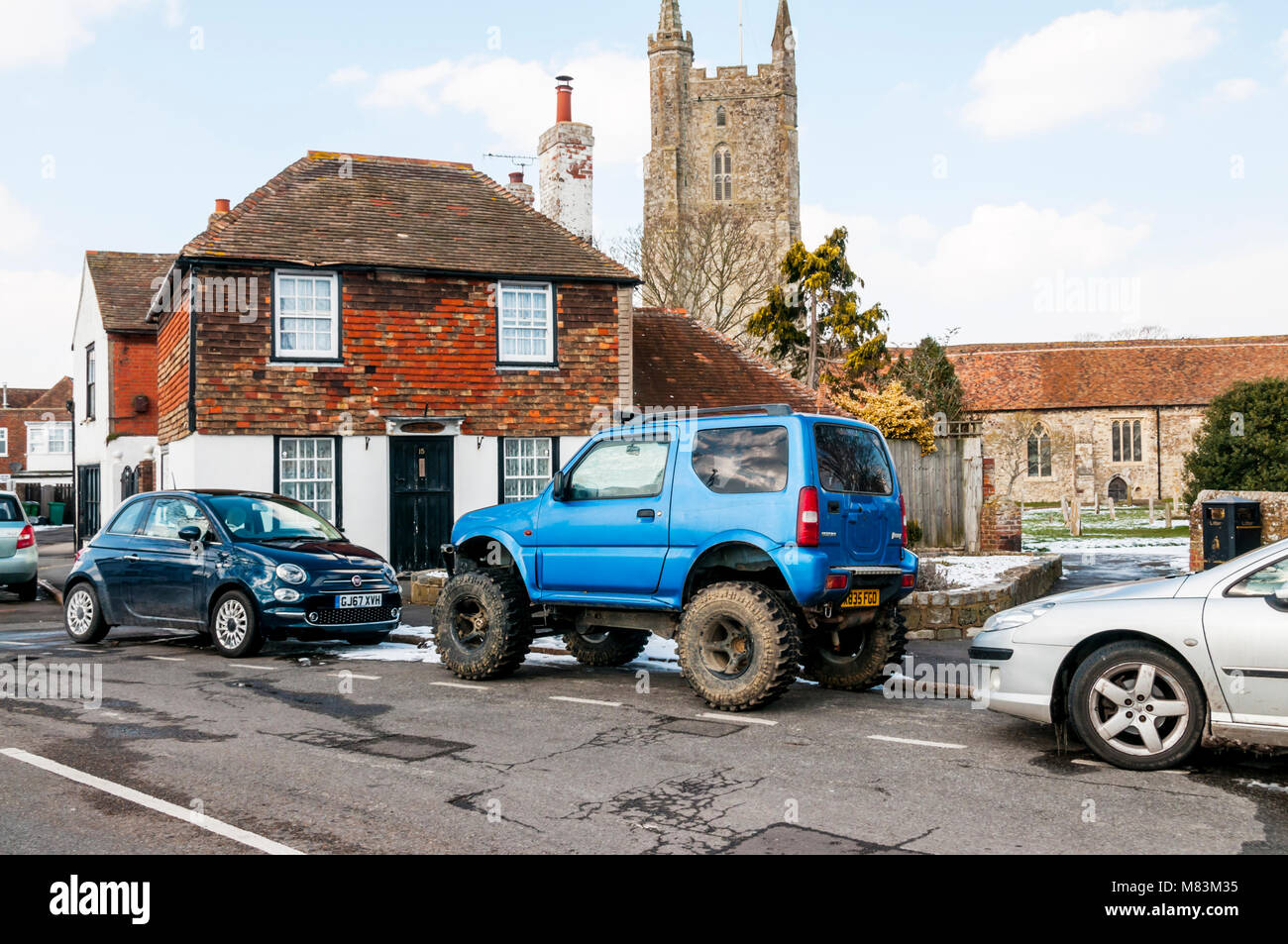 A blue Suzuki Jimny off-road 4x4 vehicle in Lydd on Romney Marsh, Kent.  With Malatesta off road tyres and lifted suspension. Stock Photo