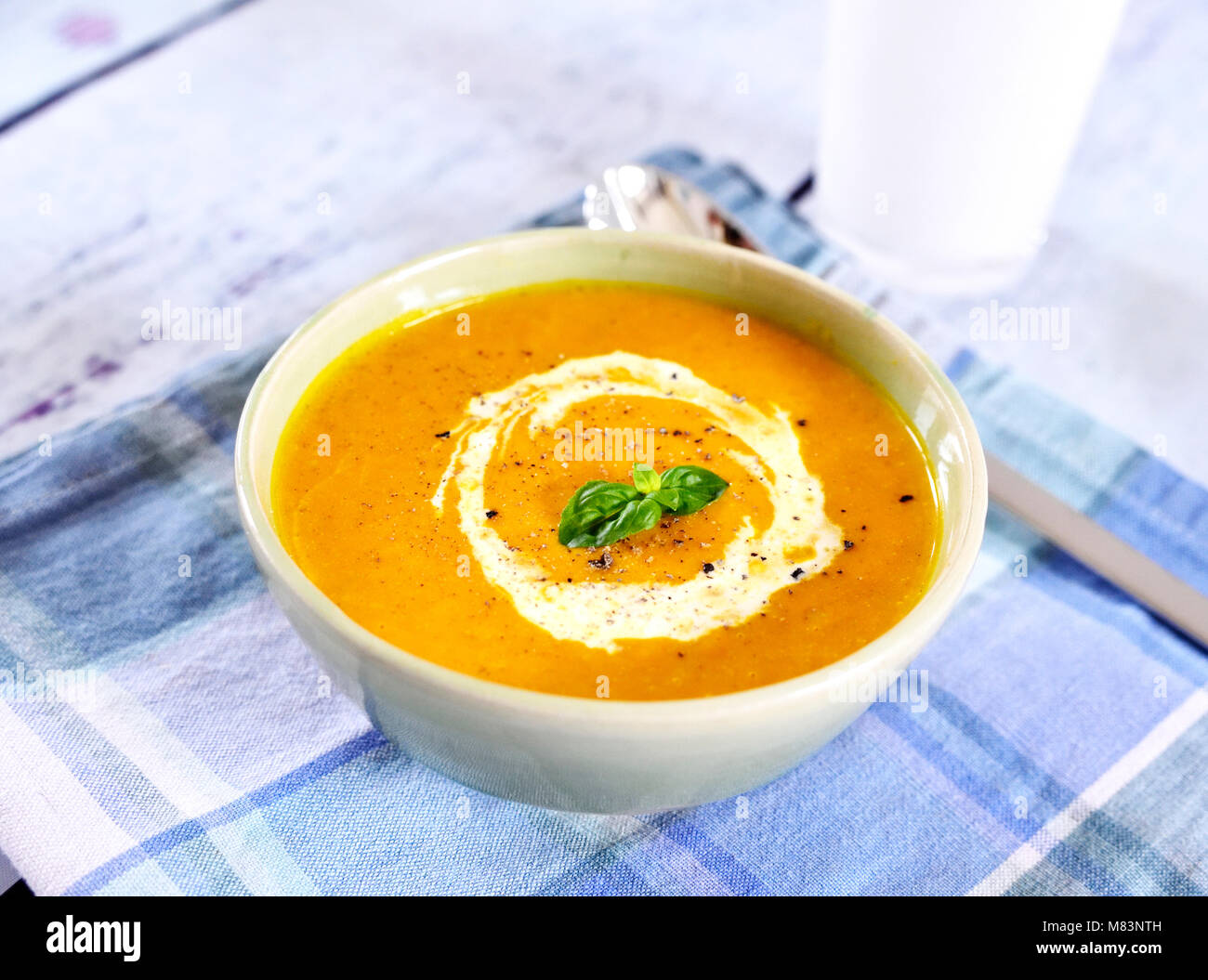 Bowl with pumpkin soup and copy space. Cream soup on a white wooden table. Stock Photo