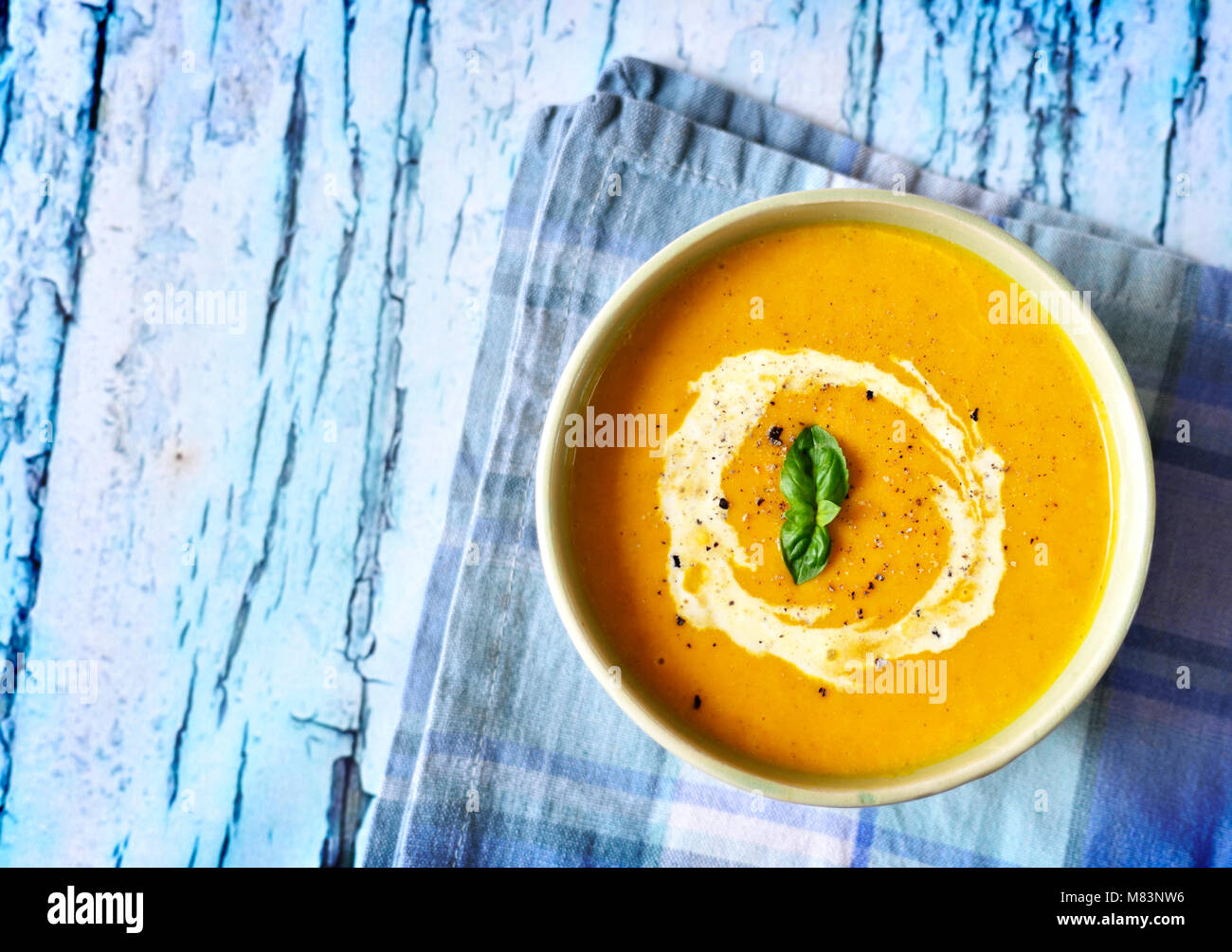Bowl with pumpkin soup and copy space. Cream soup on a white wooden table. Stock Photo