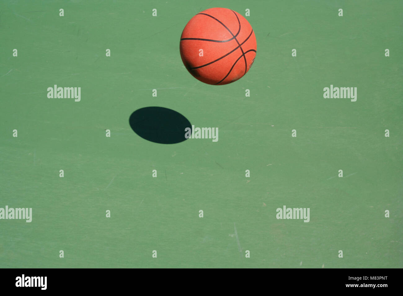 A bouncing Basketball green court with shadow Stock Photo