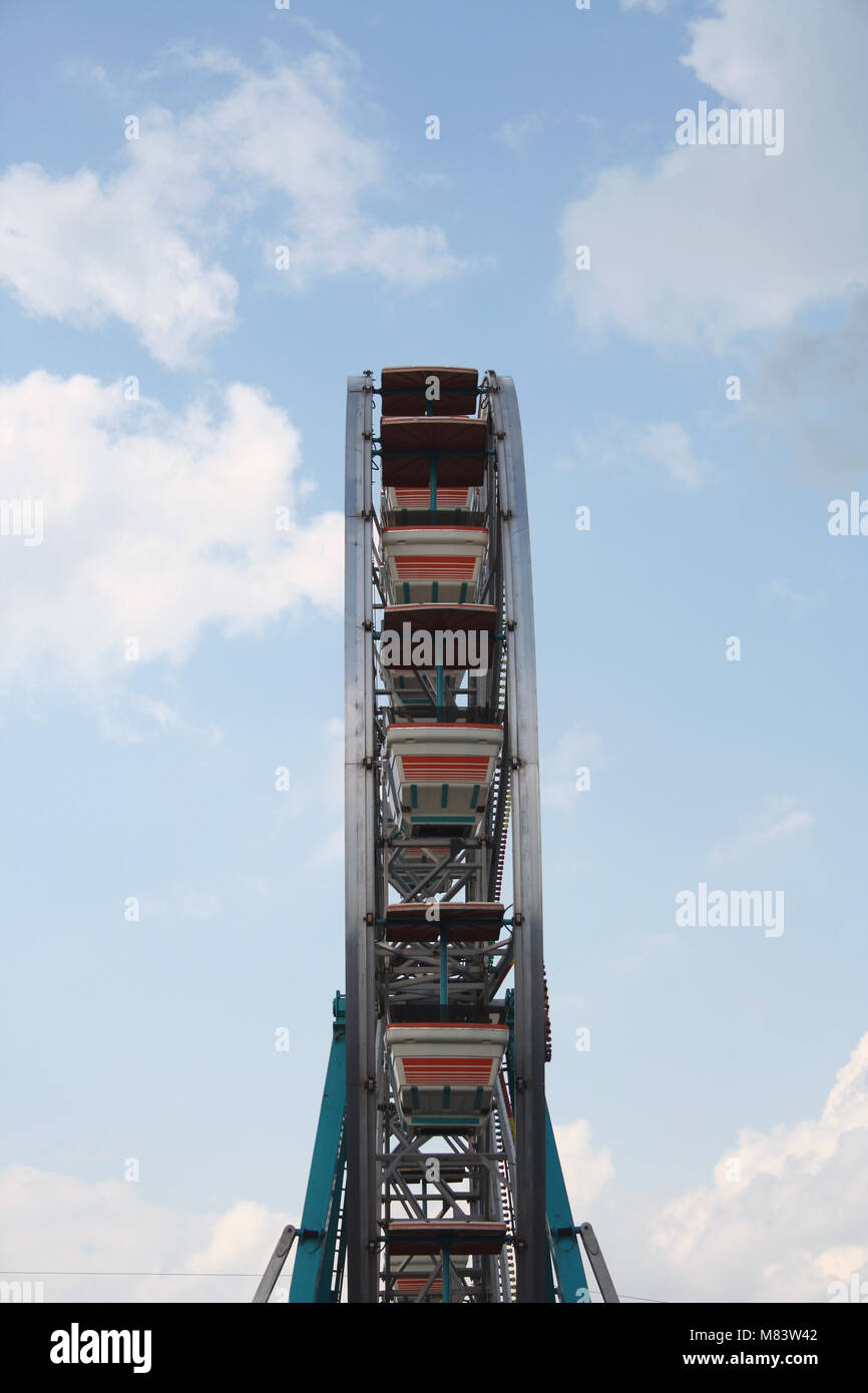 Ferris wheel against bule sky with clouds Stock Photo