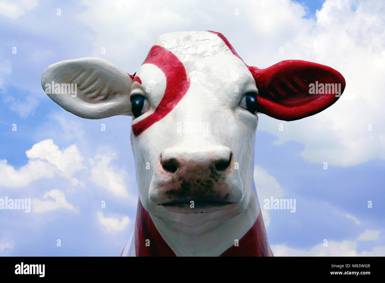 an image of a model cow against a blue sky with clouds Stock Photo - Alamy
