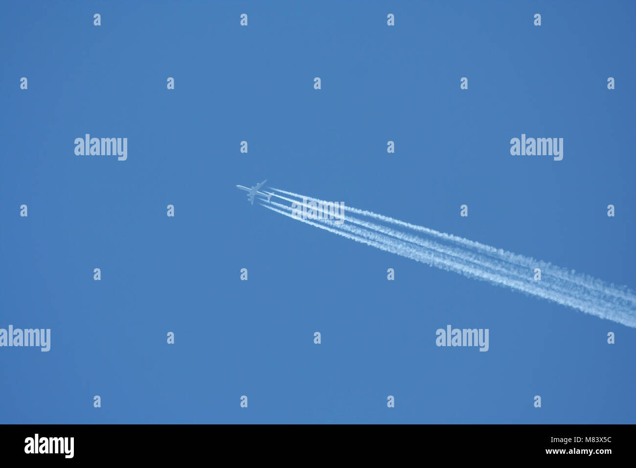 A Jet plane with exhaust on blue sky Stock Photo Alamy