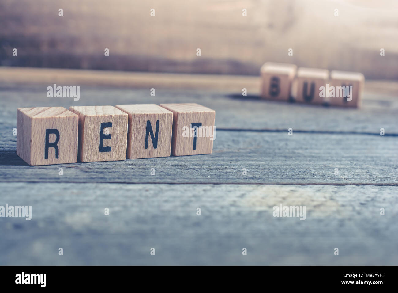 Macro Of The Words Rent And Buy Formed By Wooden Blocks On A Wooden Floor Stock Photo