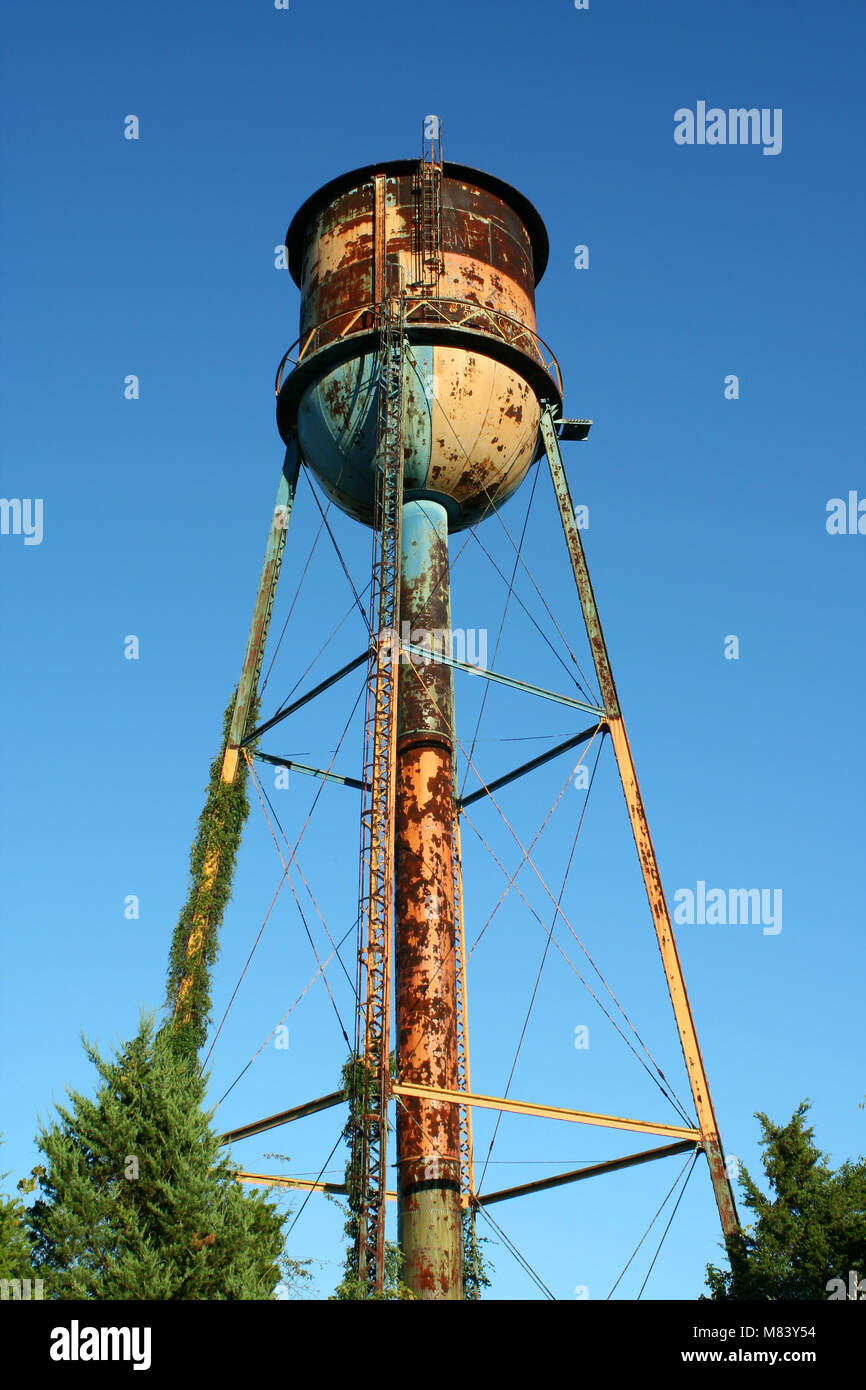 A Old rusty watertower against blue sky Stock Photo - Alamy