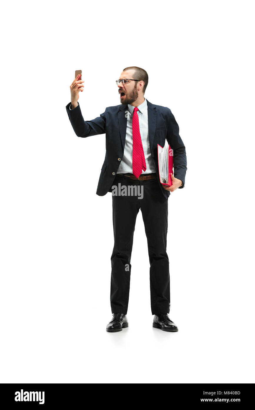 Angry businessman talking on the phone isolated over white background in studio shooting Stock Photo