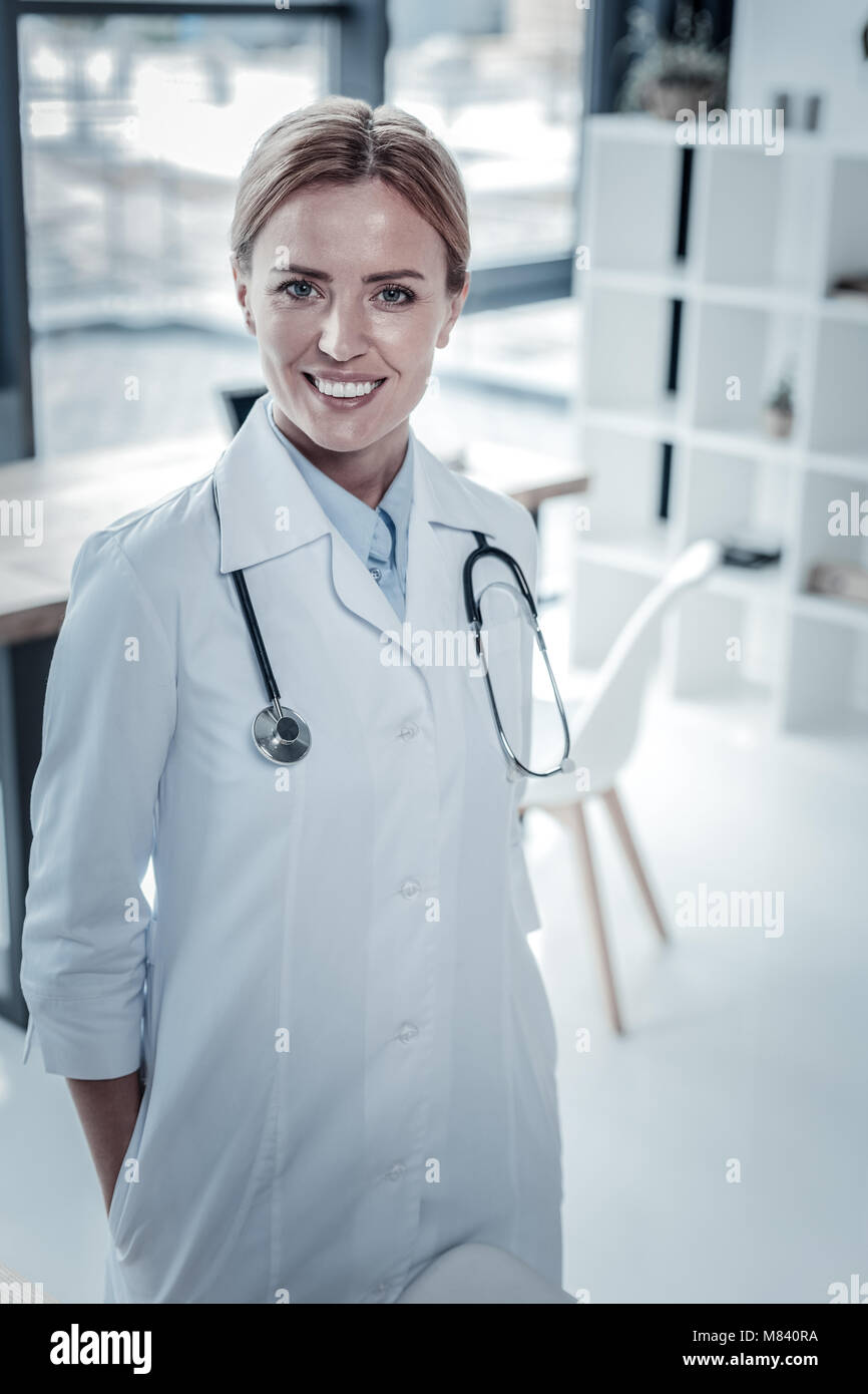 Cute confident nurse standing and smiling Stock Photo - Alamy