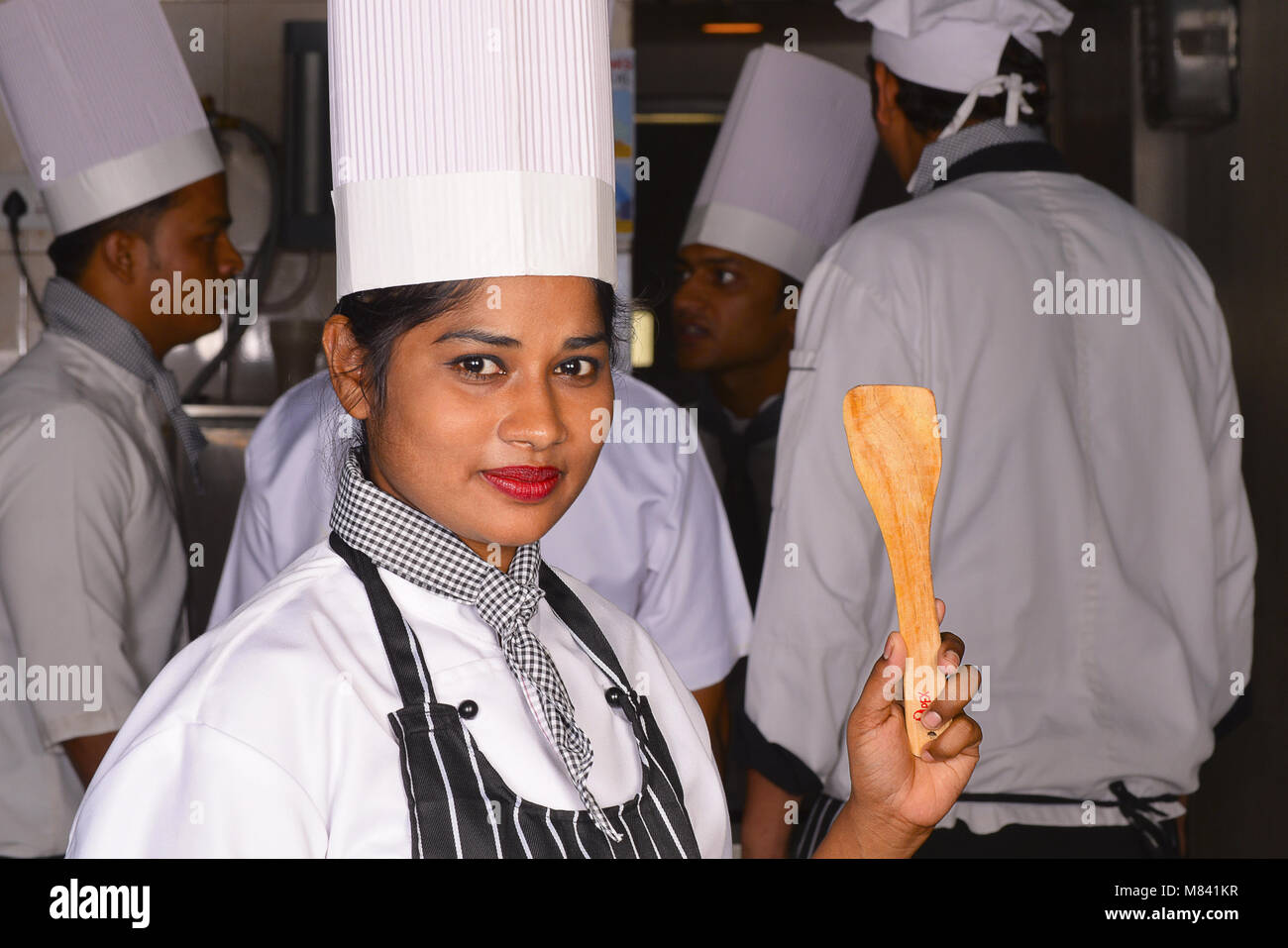 Female chef holding a wooden spatula Stock Photo