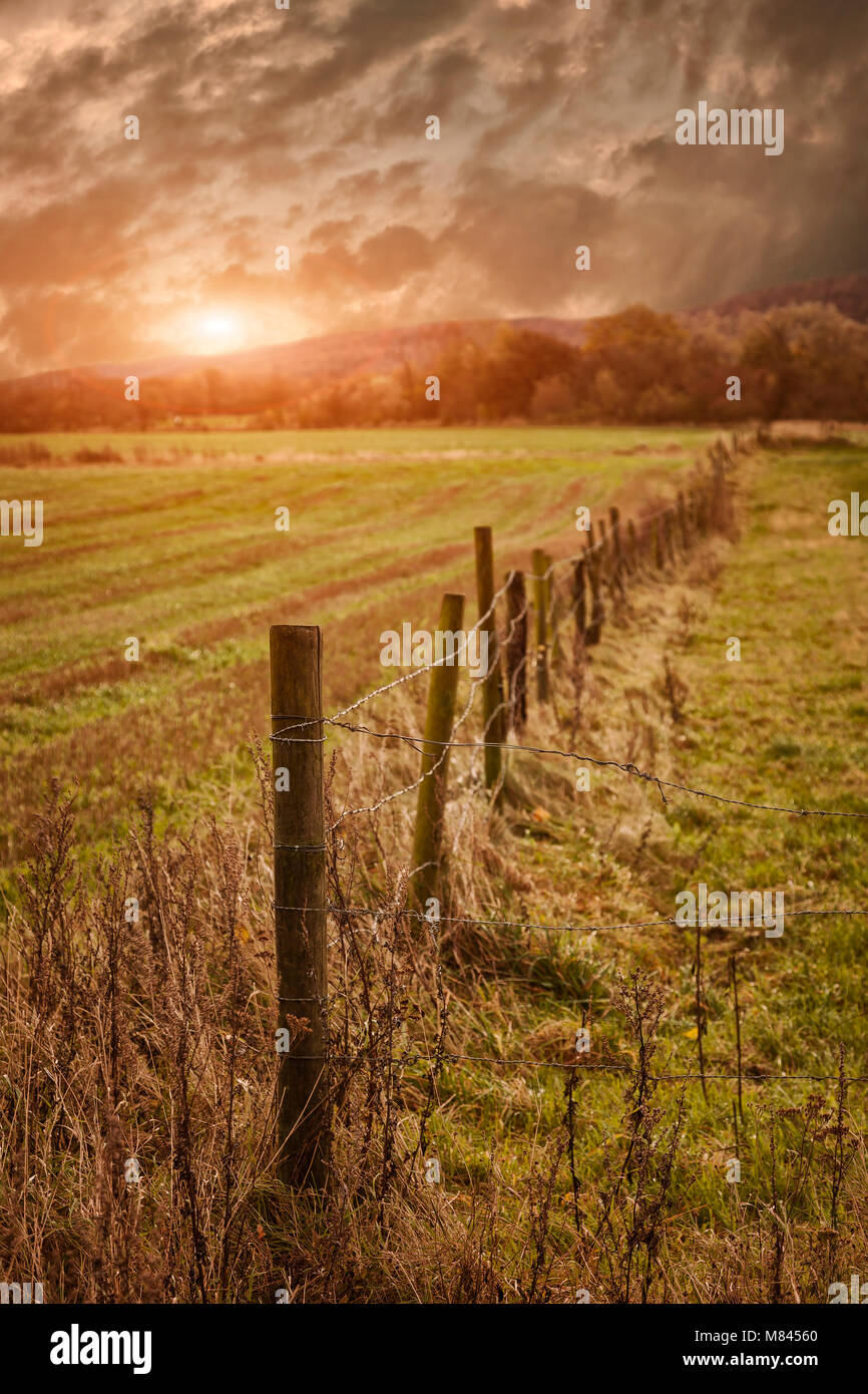 Rural farmland with wooden fence during sunrise Stock Photo - Alamy