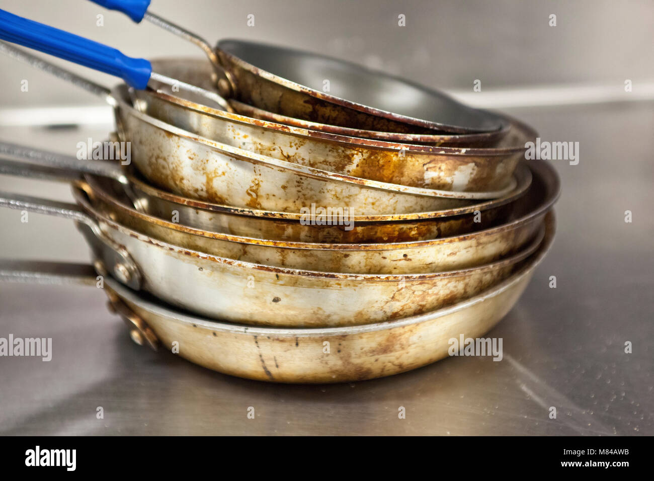 stack of dirty, worn aluminum pots in a restaurant kitchen Stock Photo