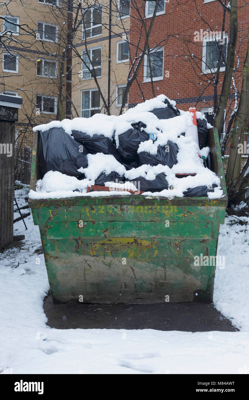 Full skip of rubbish covered in snow, Hyde Park, Leeds, England. 8th Full skip of rubbish covered in snow, Hyde Park, Leeds, England. 8th