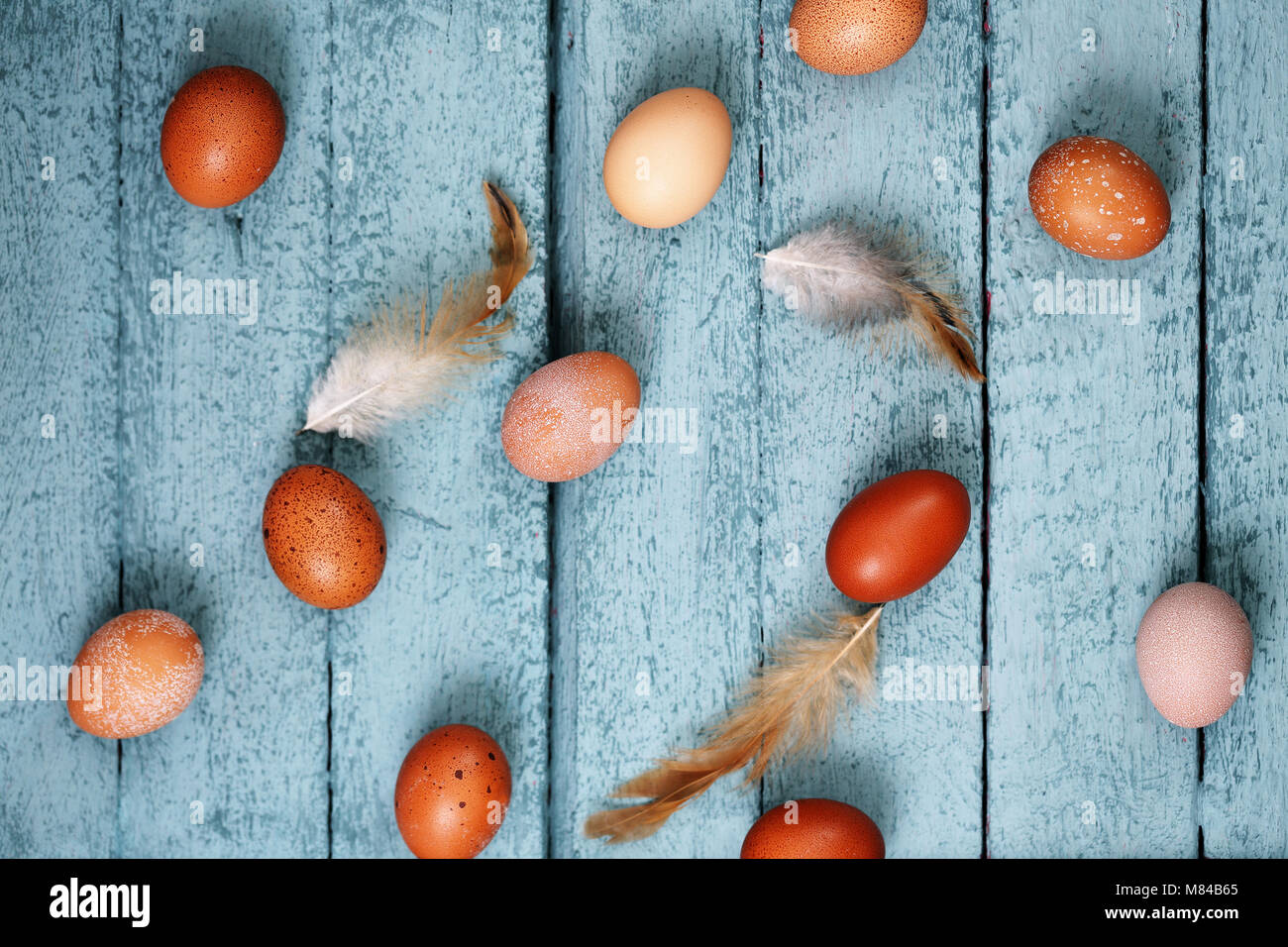 eggs with feathers on a wooden background Stock Photo - Alamy