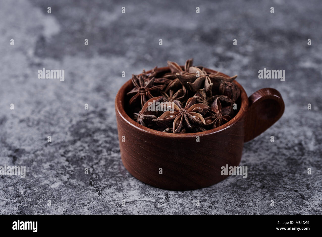 Wooden full cup of star anise Stock Photo - Alamy
