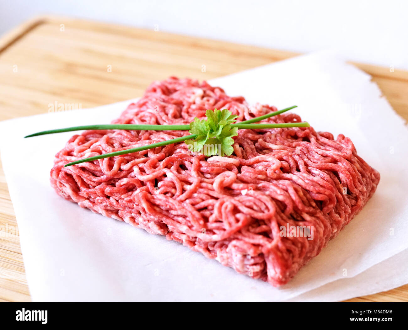 Raw minced meat or beef meat on a wooden cutting board. Fresh meat, cooking ingredient. high angle view. Stock Photo