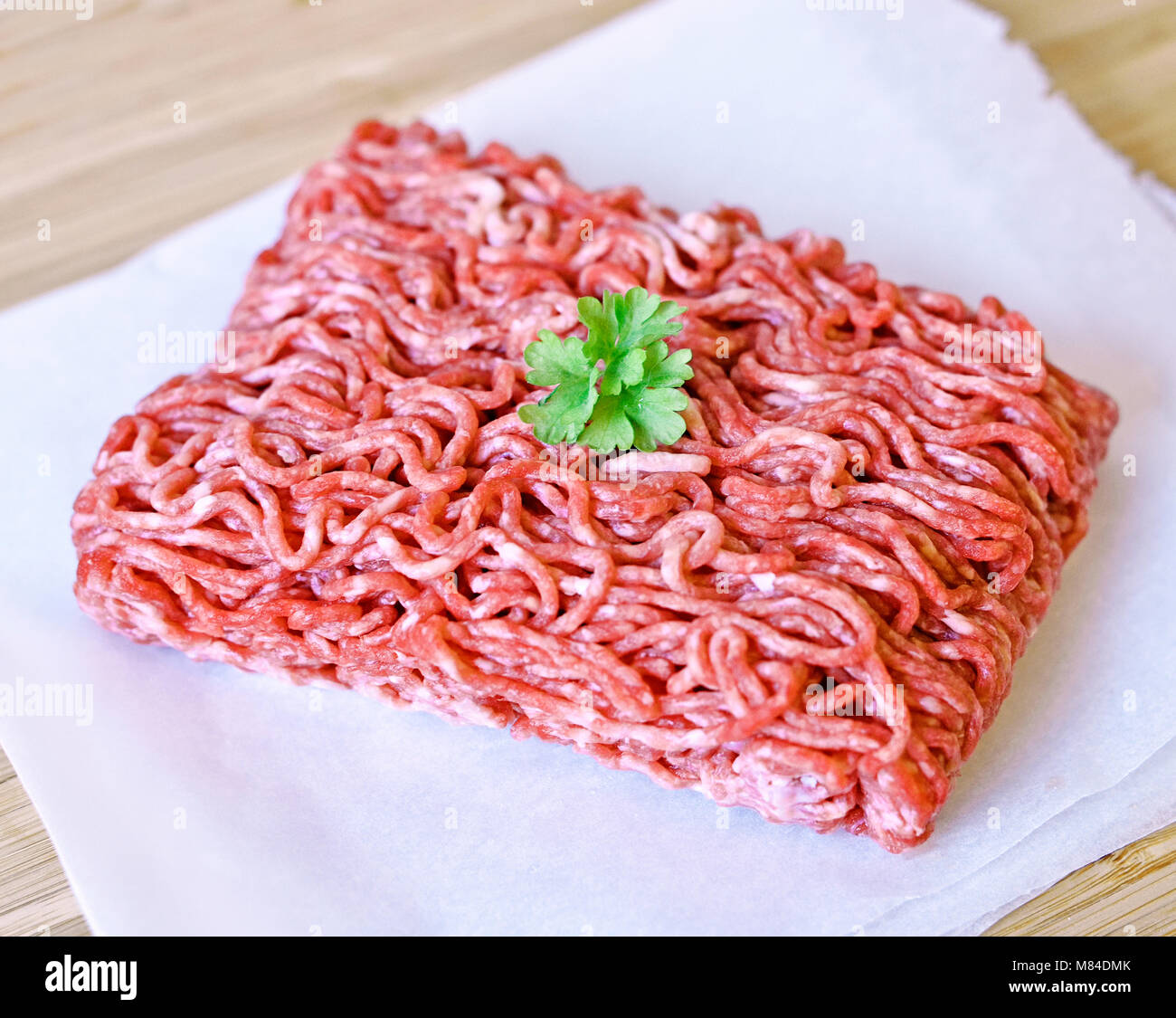 Raw minced meat or beef meat on a wooden cutting board. Fresh meat, cooking ingredient. high angle view. Stock Photo