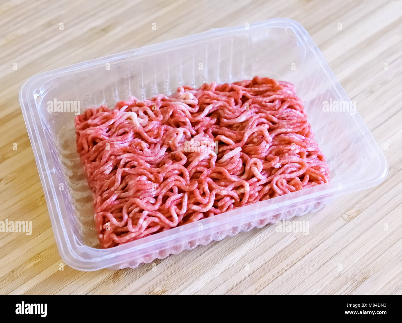 Raw minced meat or beef meat on a wooden cutting board. Fresh meat, cooking ingredient. high angle view. Stock Photo