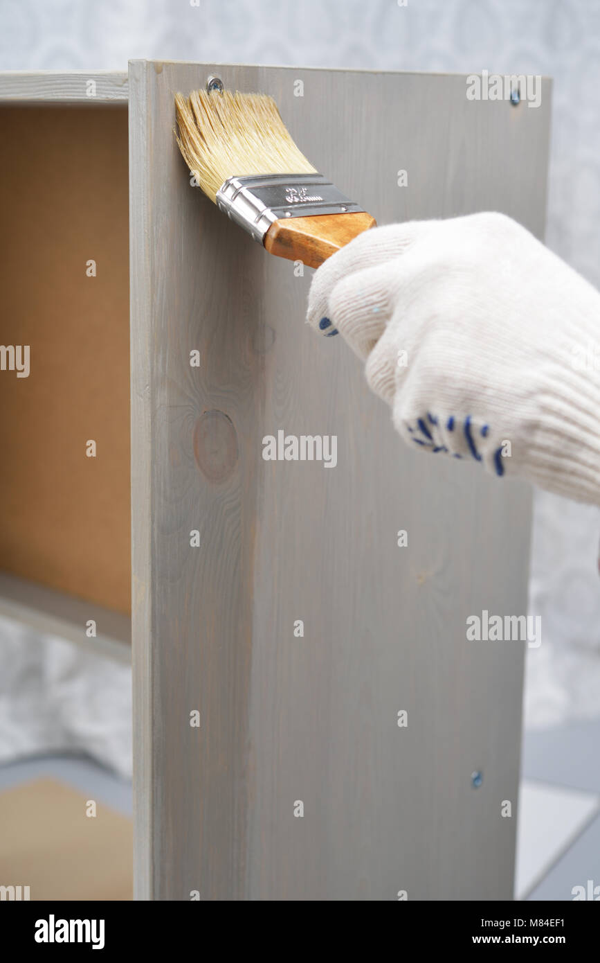 Contractor varnishing the wooden chest Stock Photo