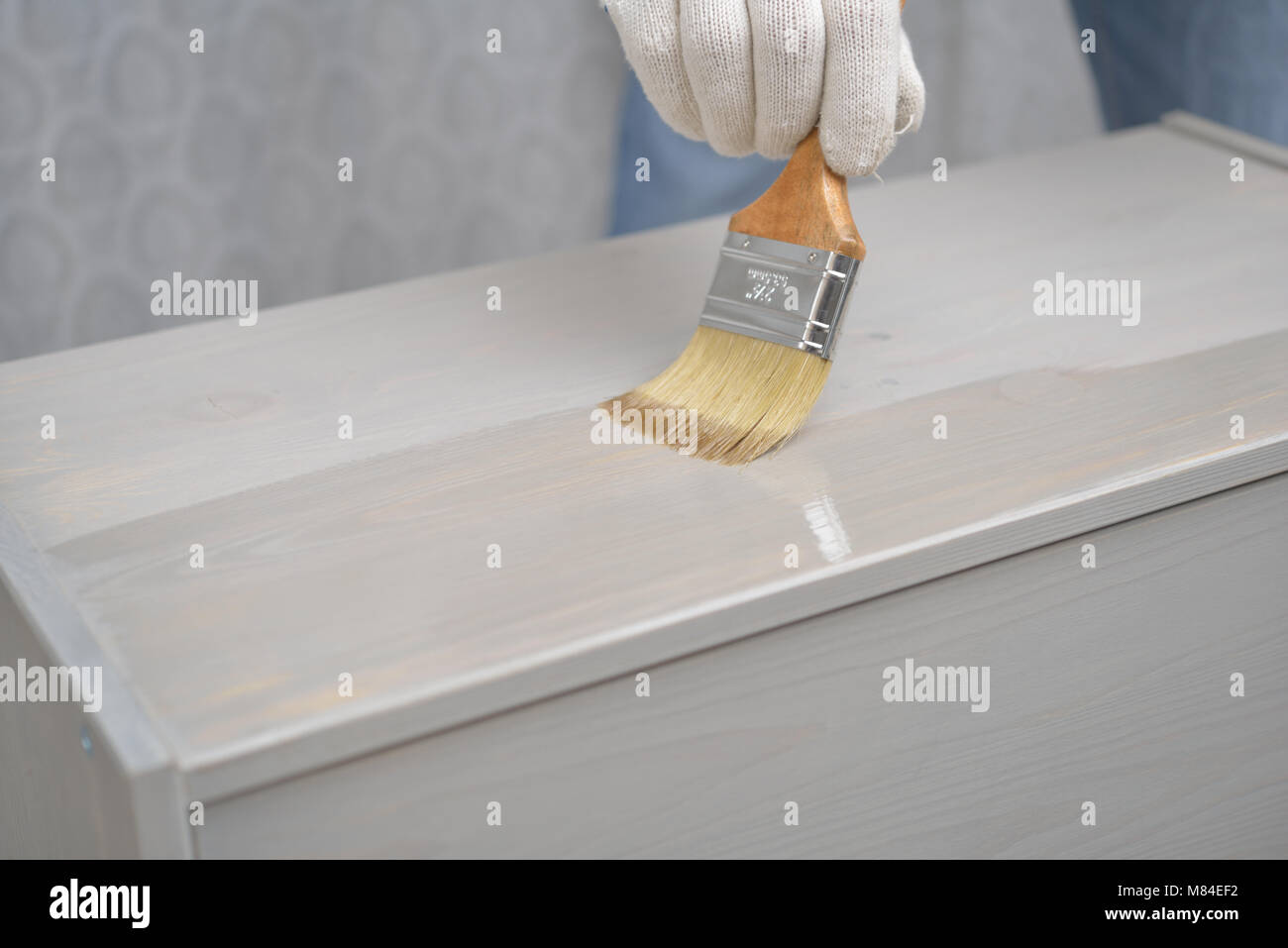 Contractor varnishing the wooden chest Stock Photo