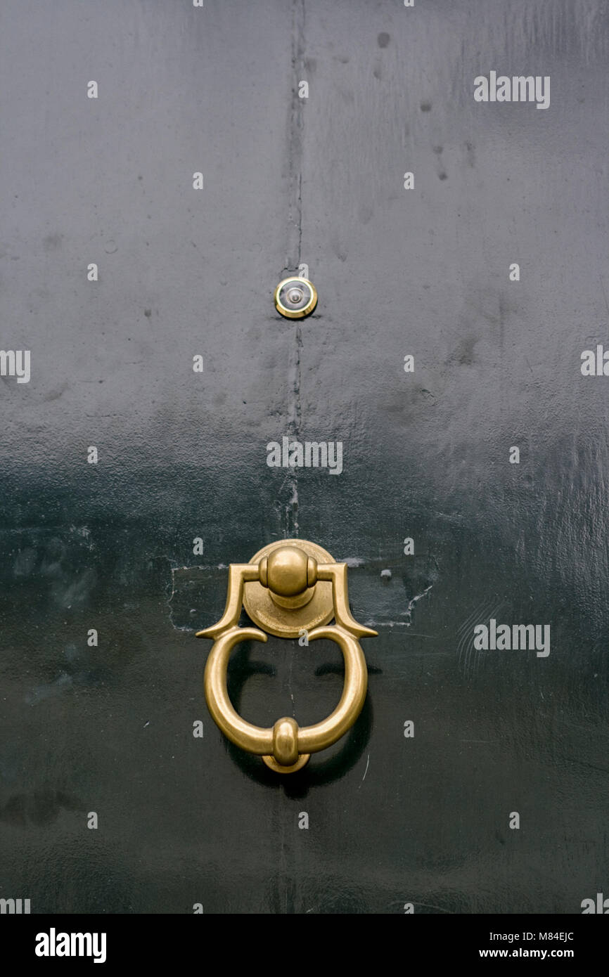 Copper Door Knocker On Wooden Door With Peephole Stock Photo