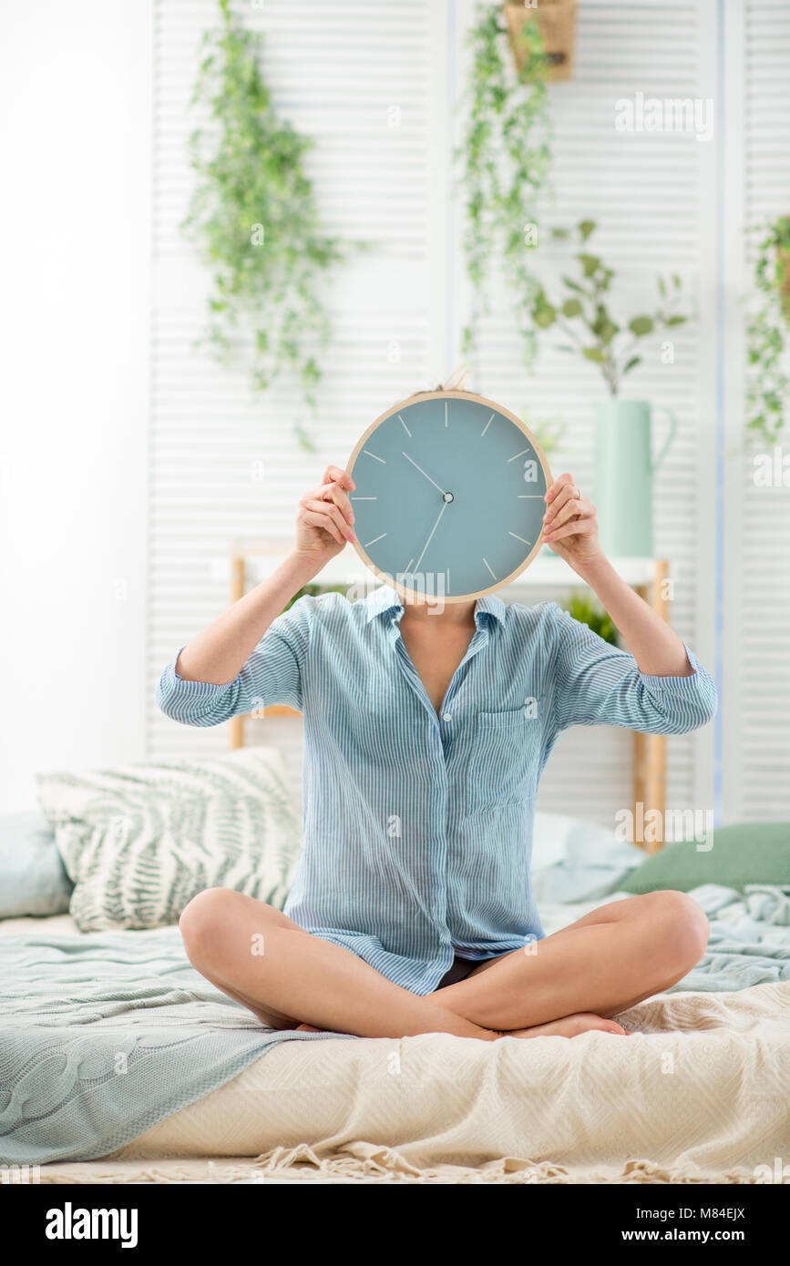 Woman with clock in the bedroom Stock Photo Alamy